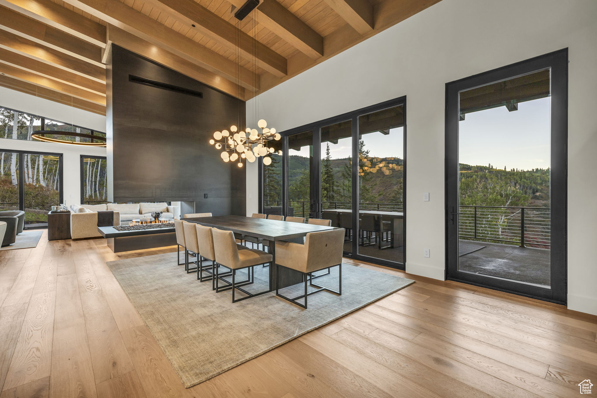 Dining area with beamed ceiling, a towering ceiling, light hardwood / wood-style floors, and wood ceiling