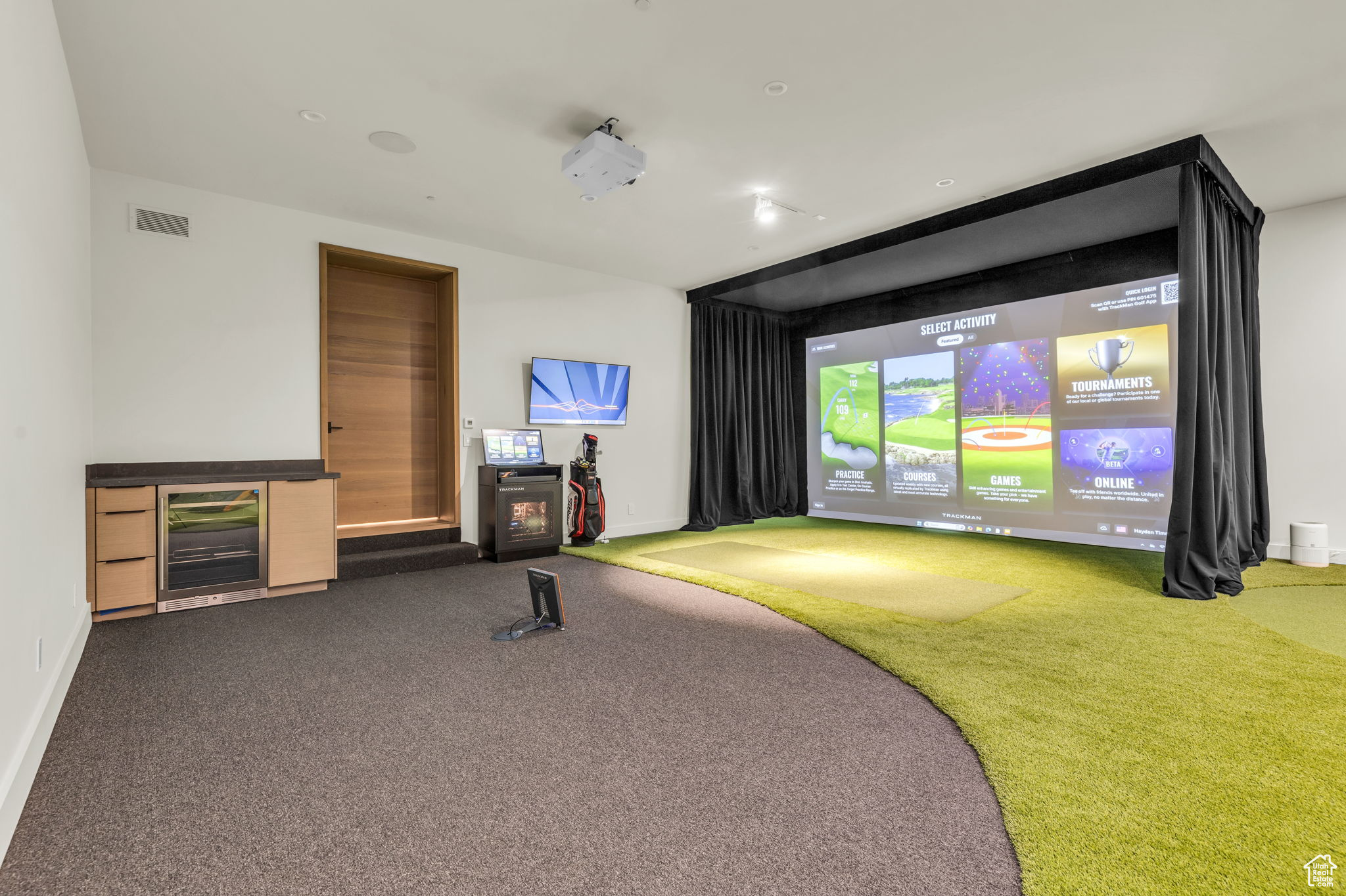 Rec room featuring wine cooler, dark carpet, and golf simulator