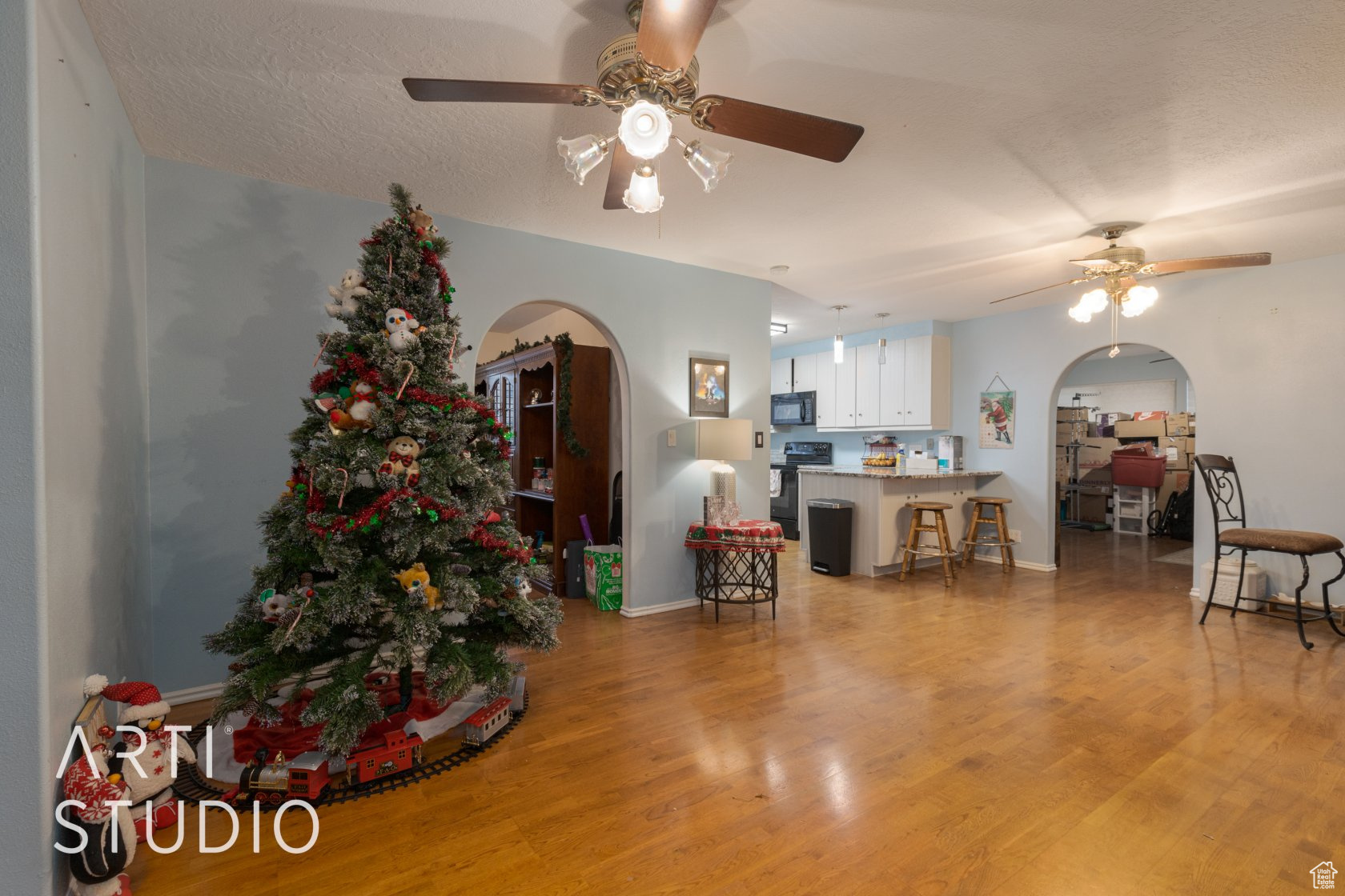 Living room with light hardwood / wood-style flooring, ceiling fan, and lofted ceiling