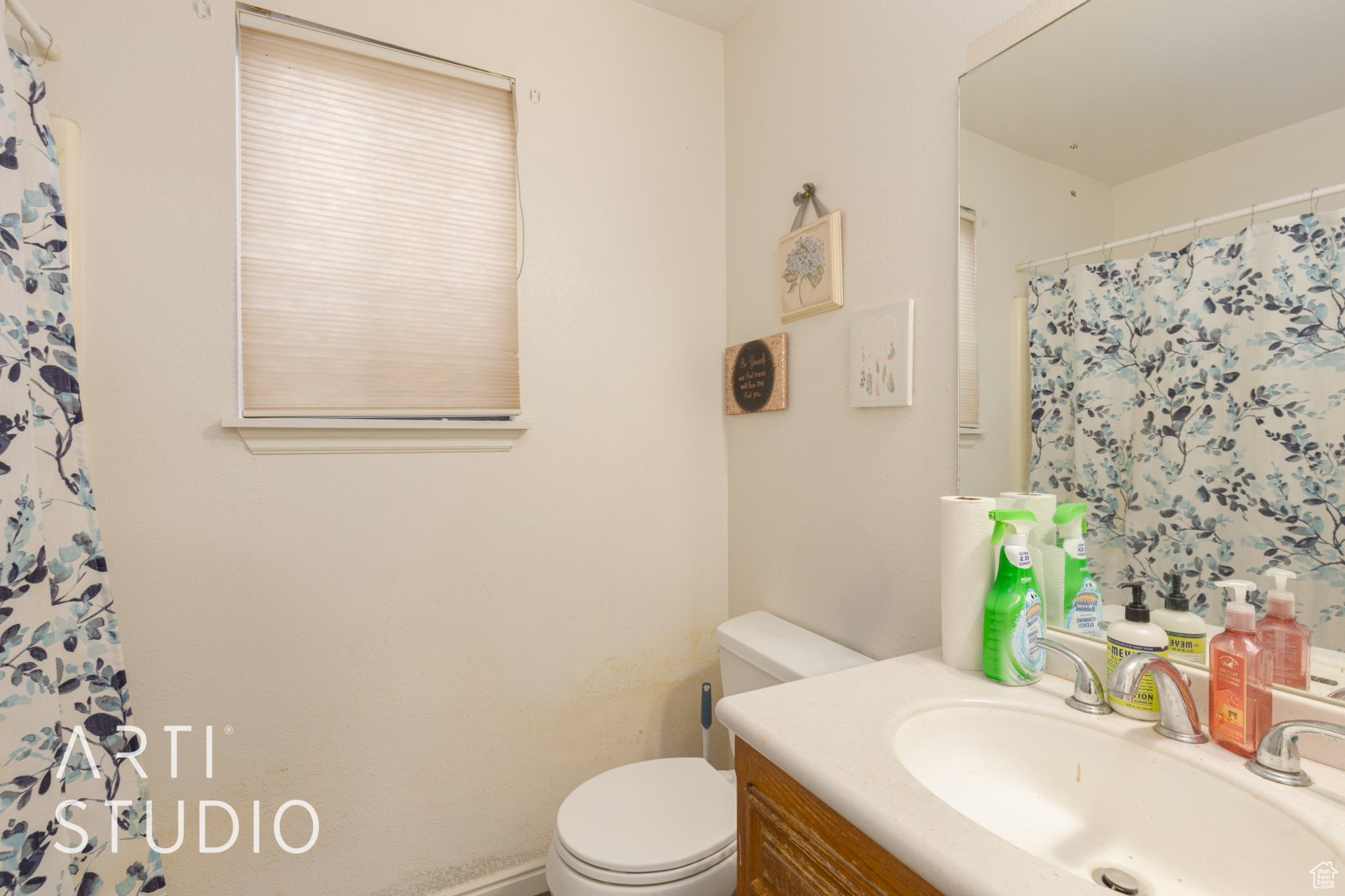 Bathroom featuring vanity, curtained shower, and toilet