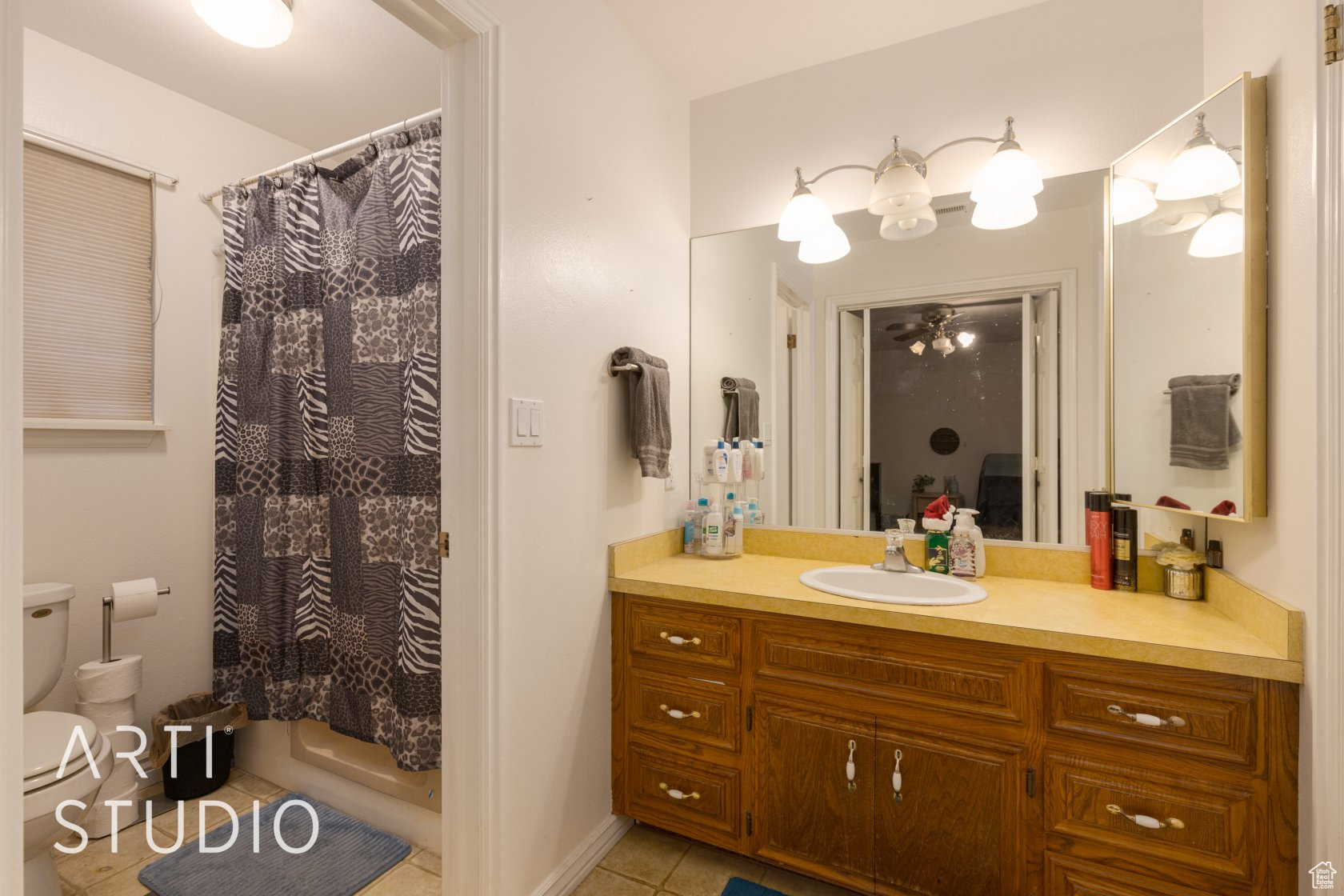 Bathroom with tile patterned floors, vanity, toilet, and walk in shower