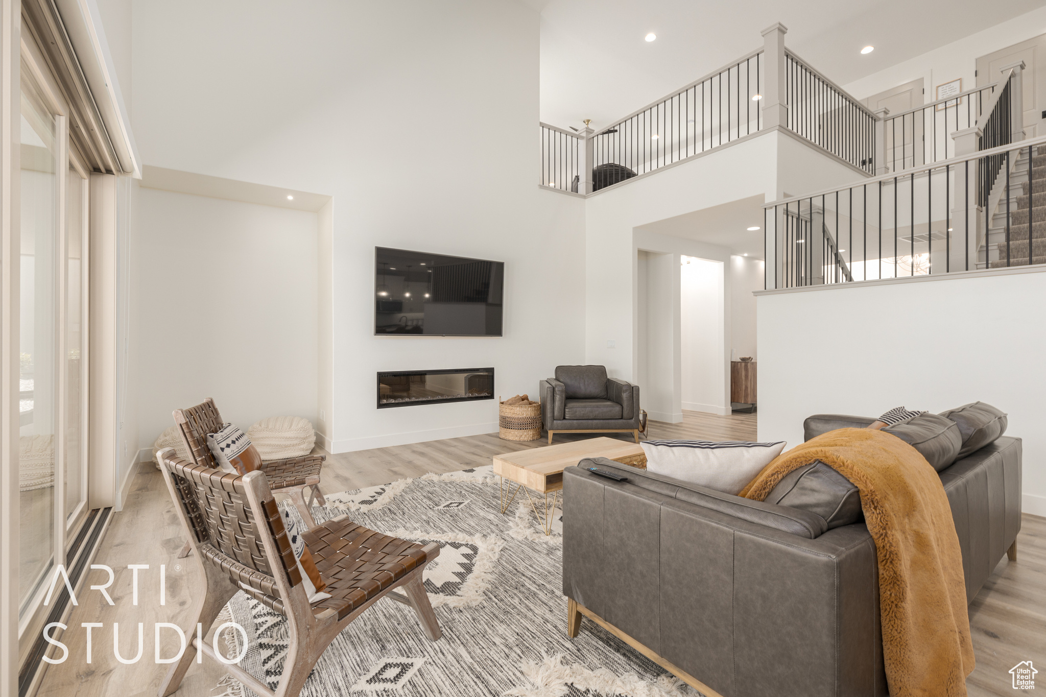 Living room featuring a high ceiling and light hardwood / wood-style flooring