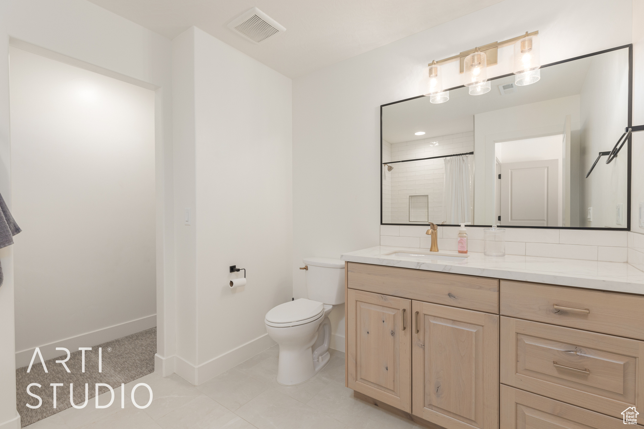 Bathroom featuring a shower with curtain, vanity, and toilet. Ensuite Bedroom #5.