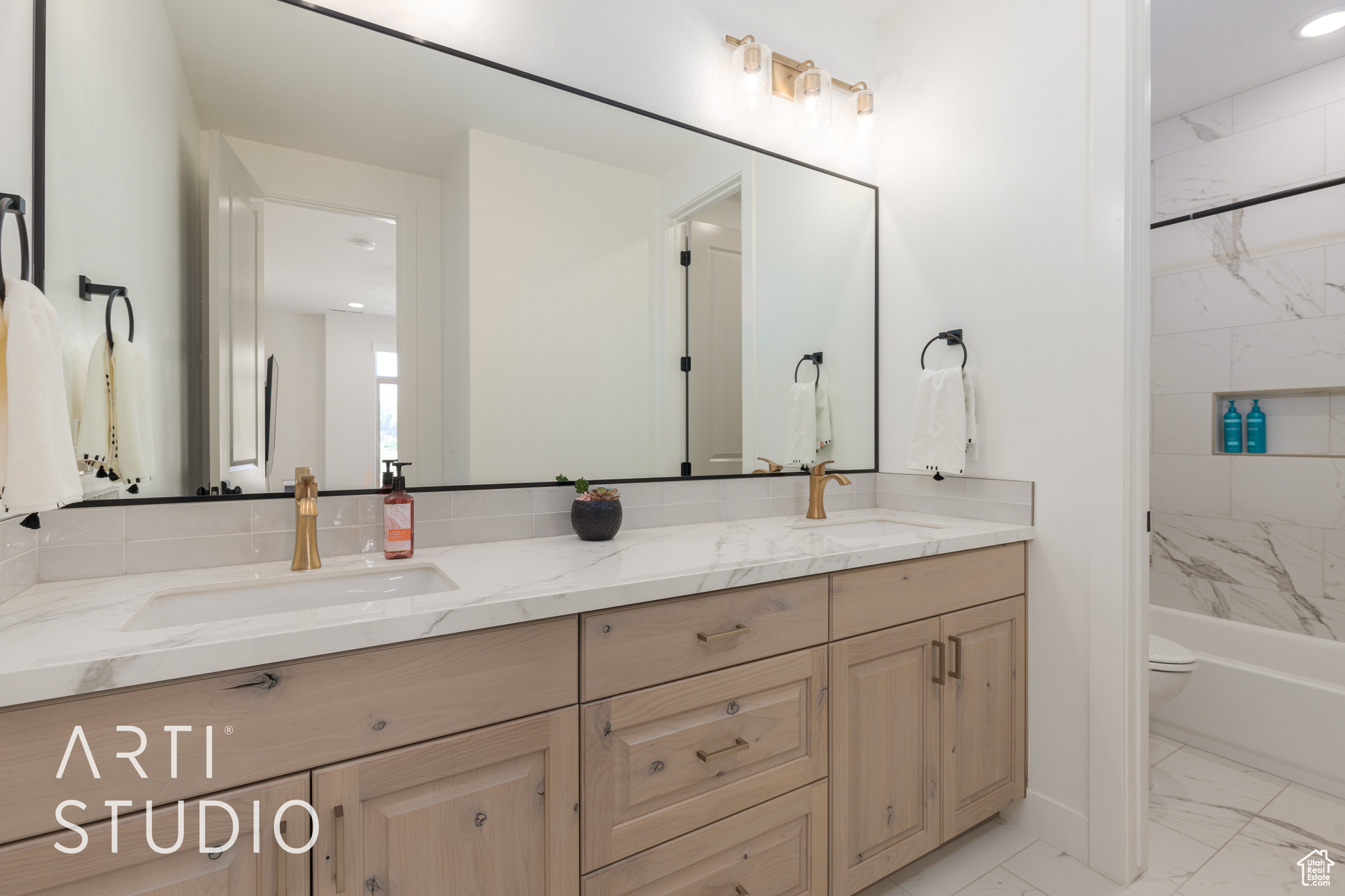 Full bathroom featuring vanity, toilet, and tiled shower / bath combo. Ensuite bedroom #2.