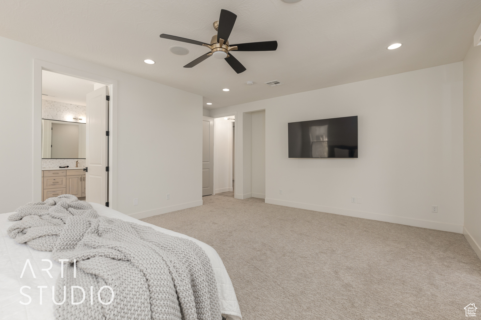 Primary Bedroom featuring light carpet, connected bathroom, and ceiling fan