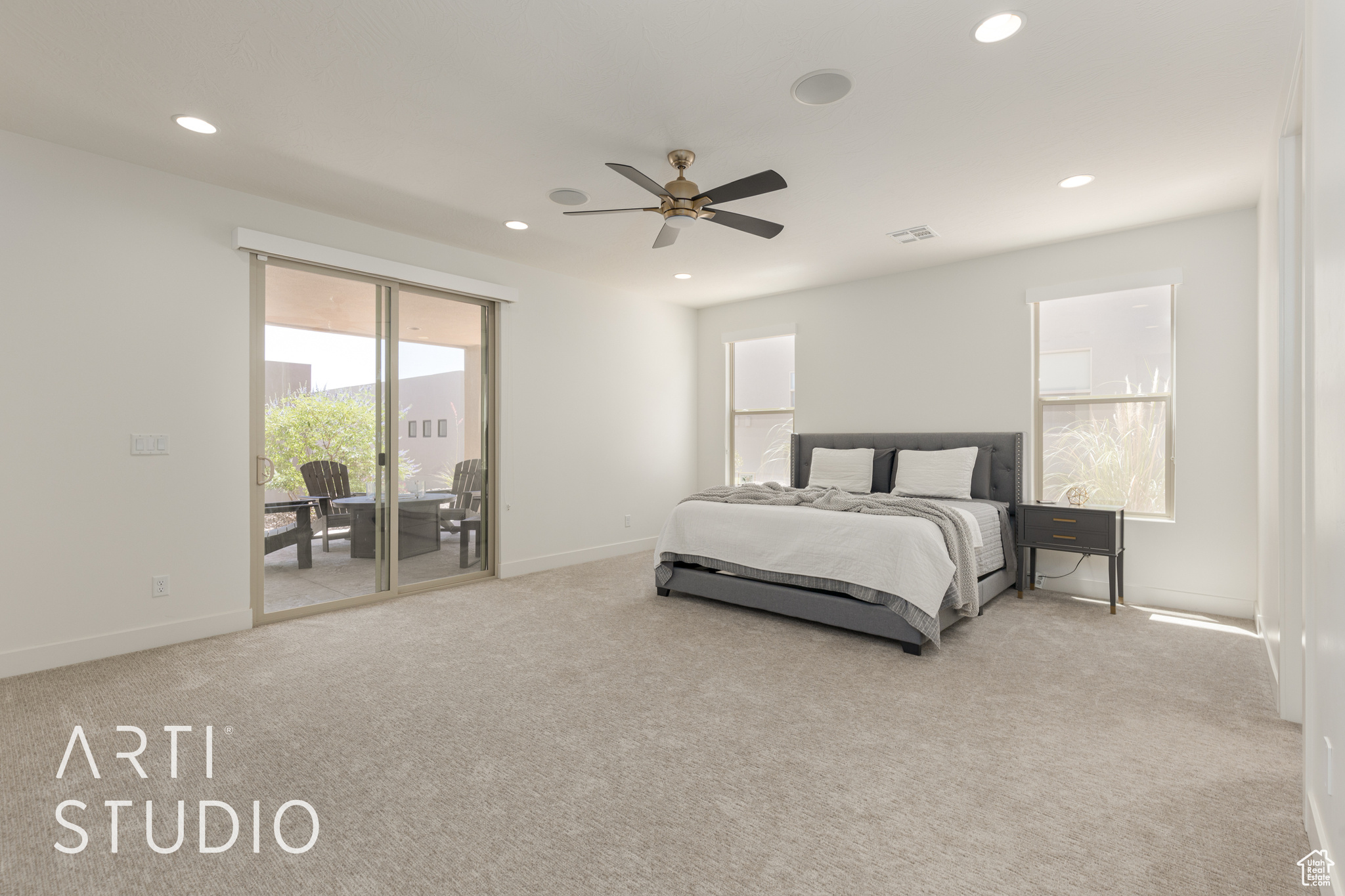 Primary Bedroom with access to exterior, light carpet, and ceiling fan