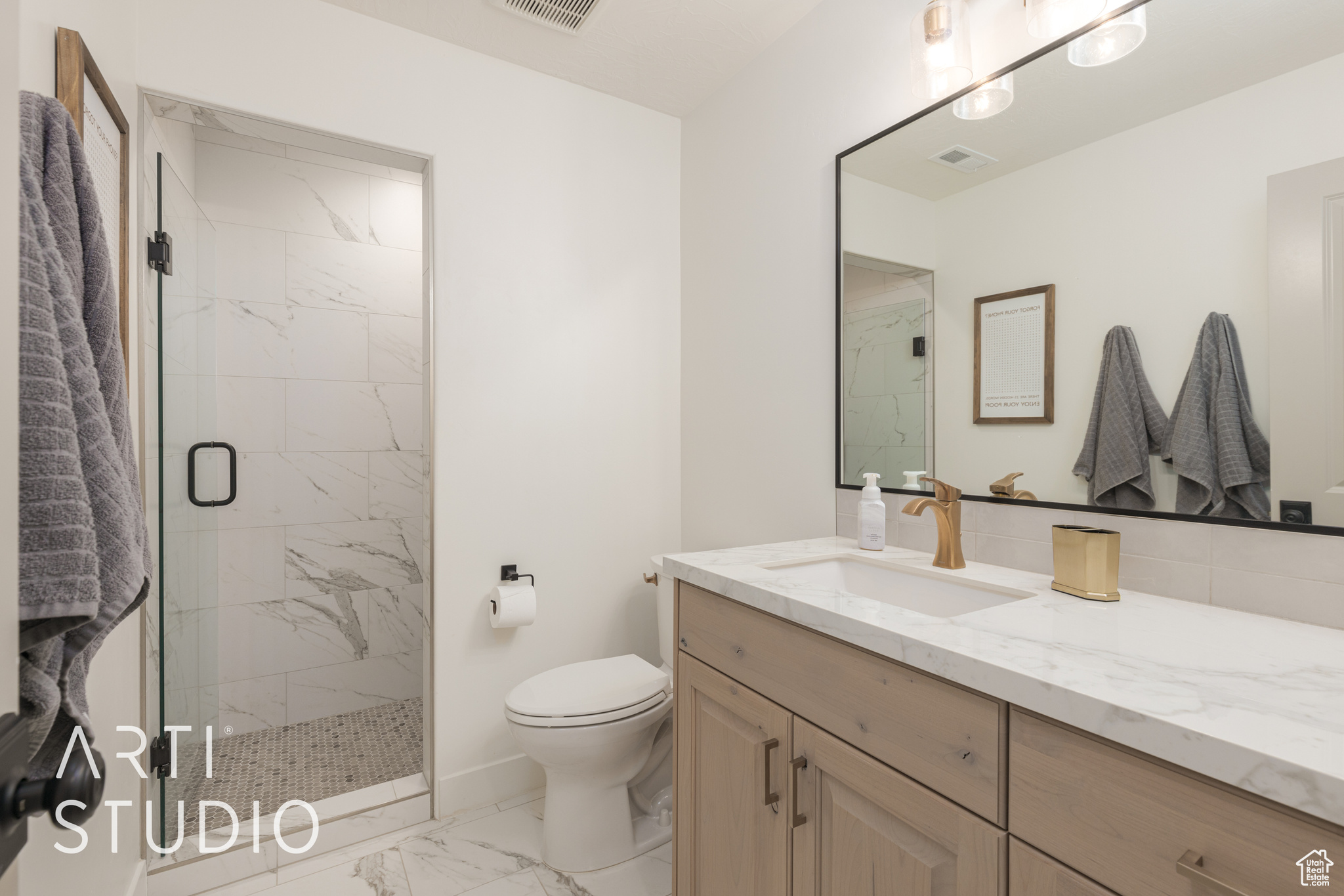 Bathroom with vanity, toilet, and a shower with shower door