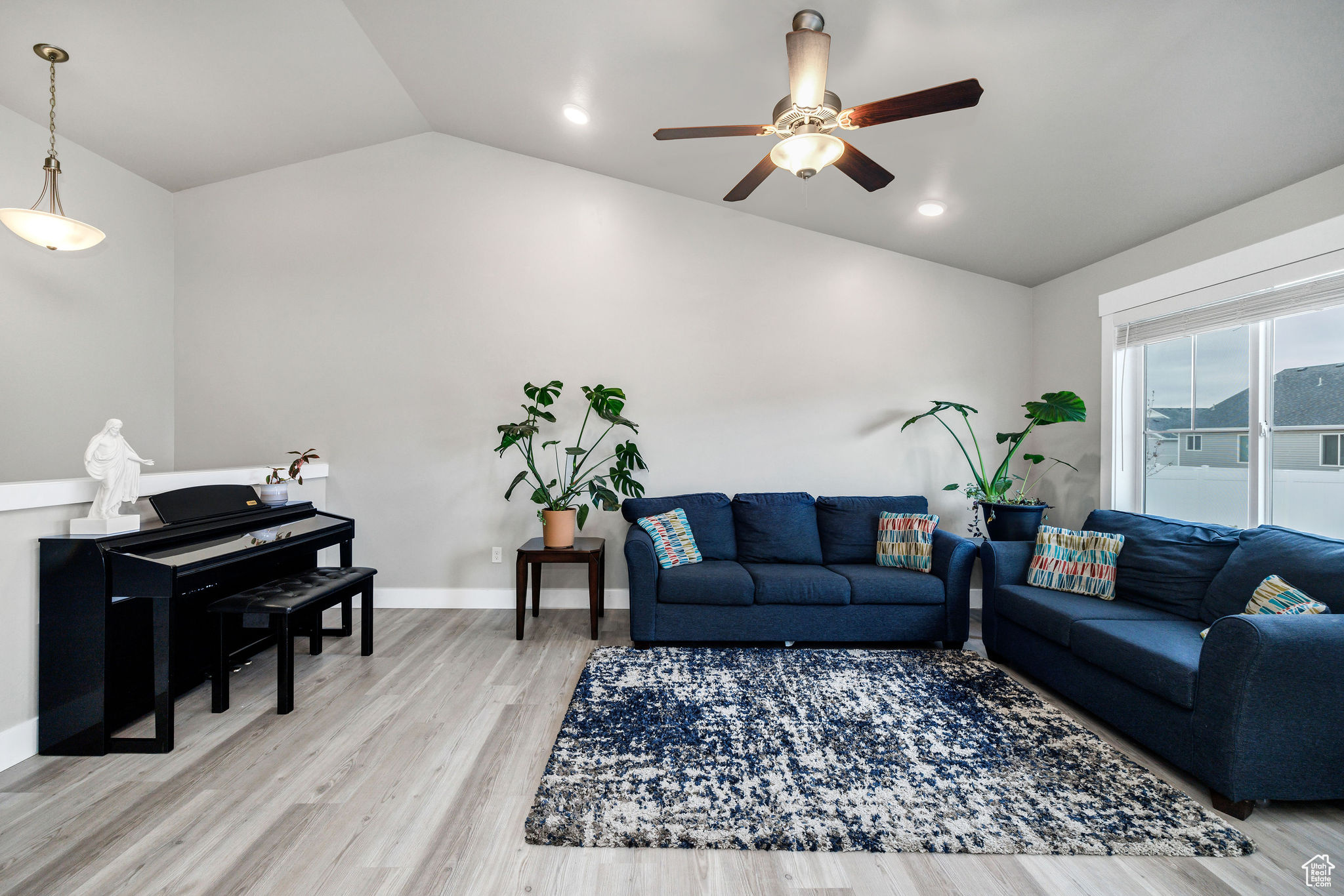 Living room featuring ceiling fan, vaulted ceiling, and hardwood / wood-style flooring