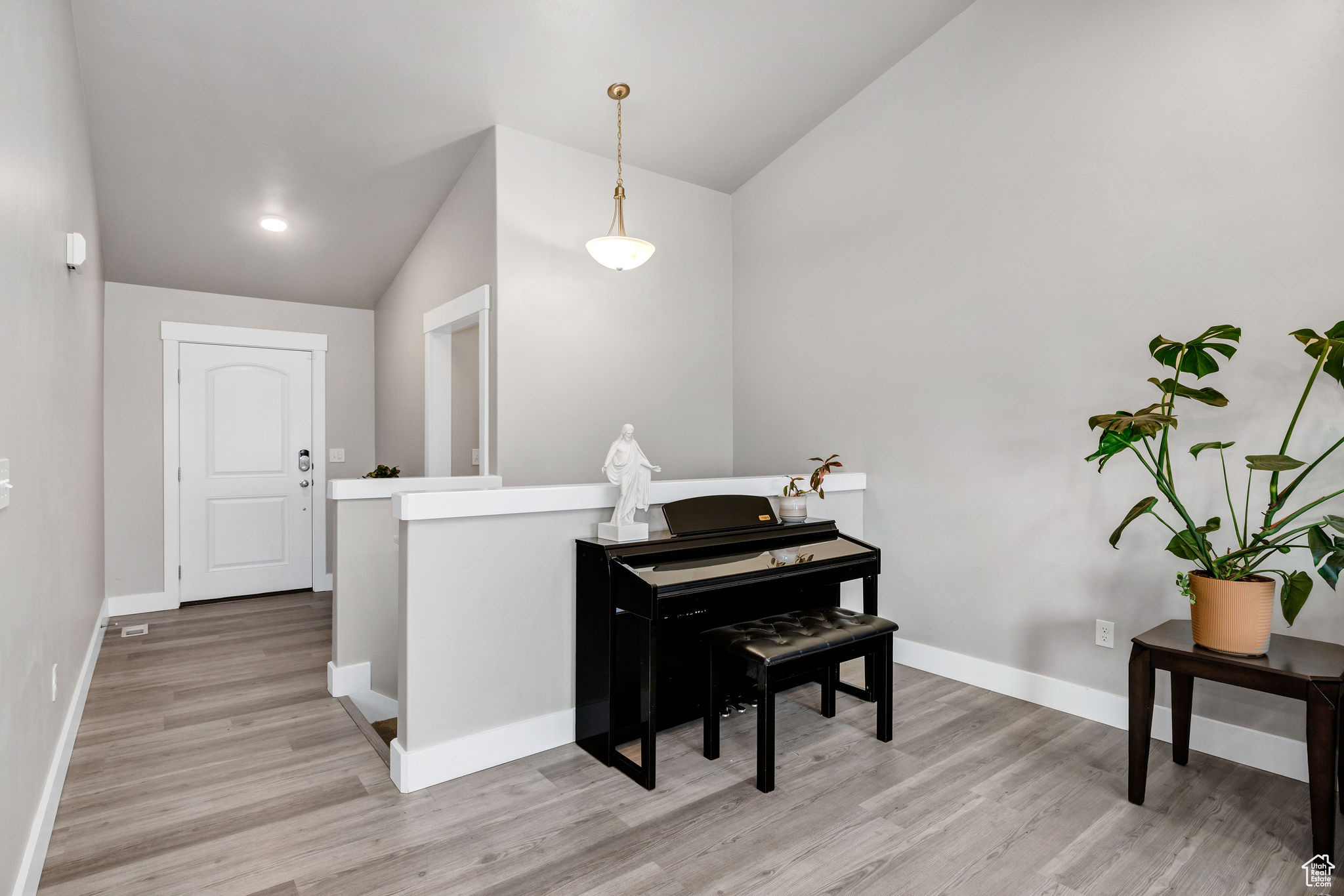 Misc room with light hardwood / wood-style floors and vaulted ceiling