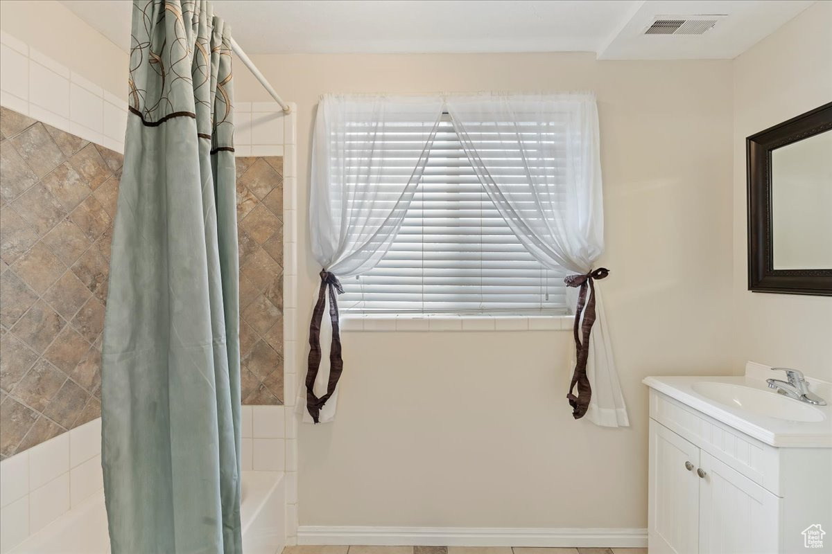 Bathroom featuring shower / tub combo with curtain and vanity