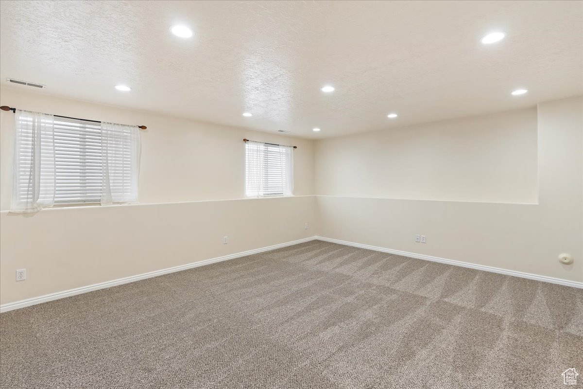 Empty room featuring carpet flooring and a textured ceiling