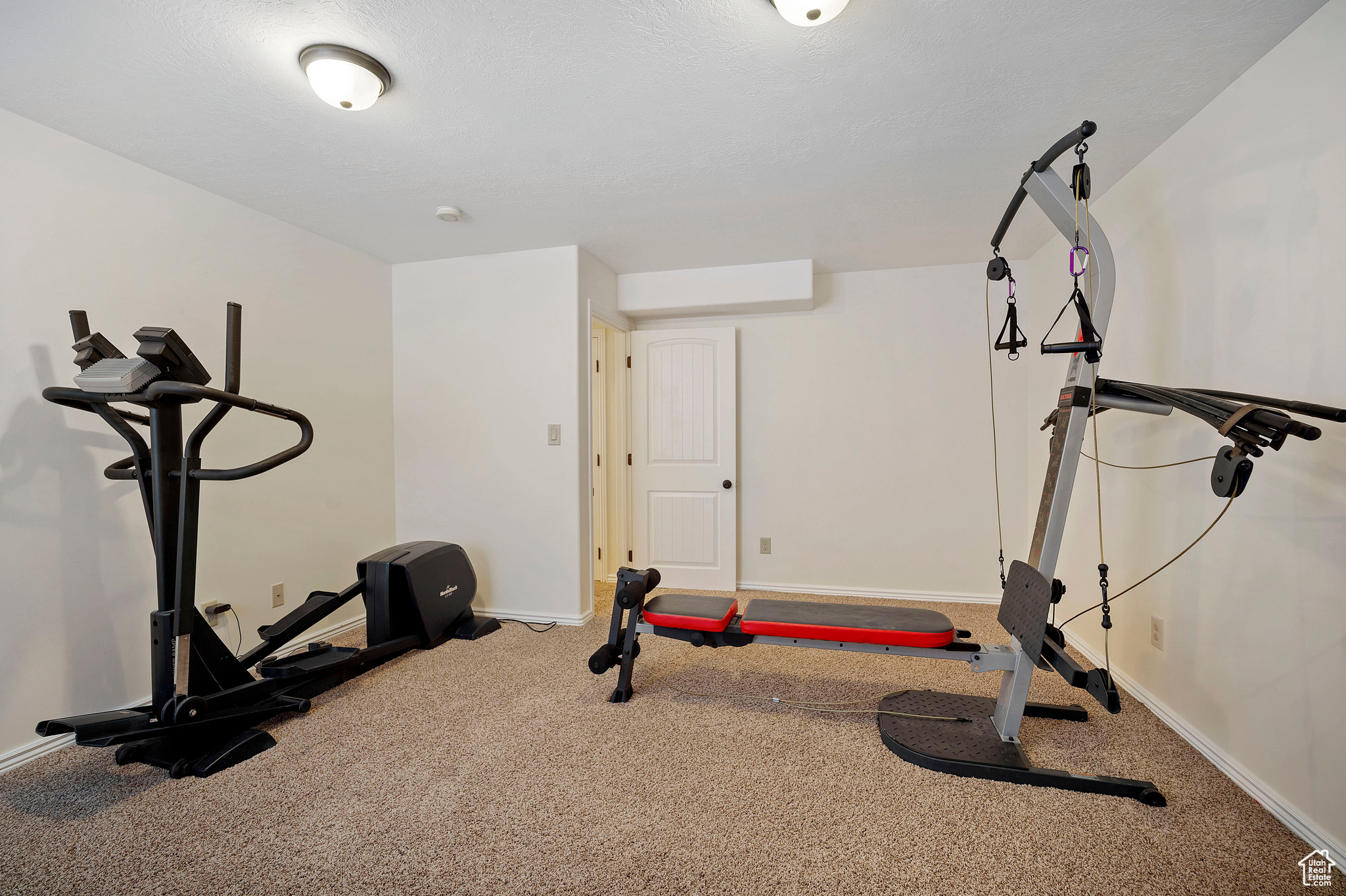 Workout room with carpet and a textured ceiling