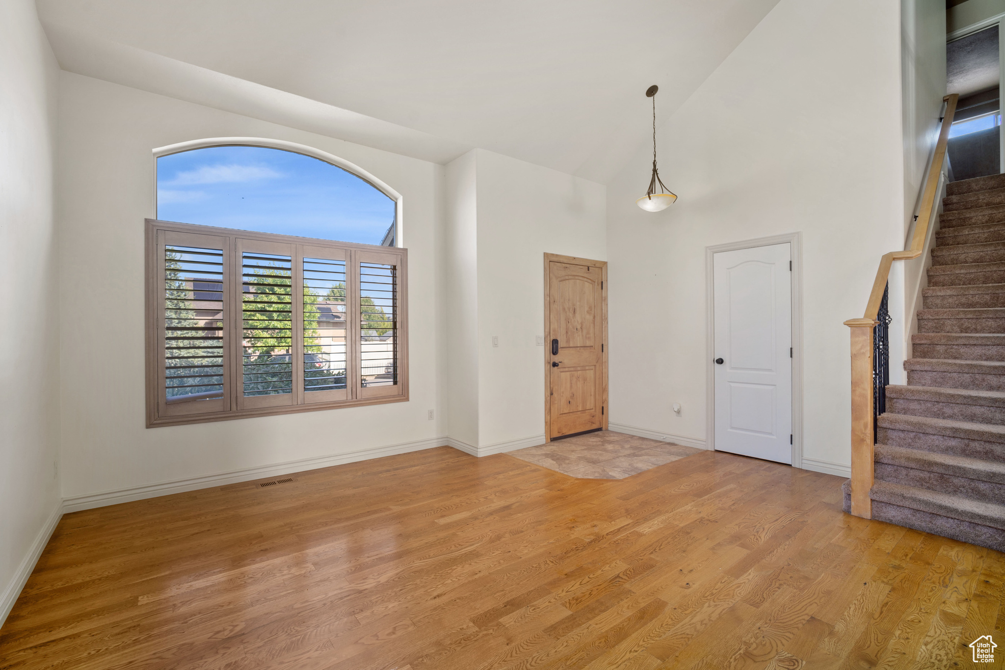 Interior space featuring a high ceiling and light hardwood / wood-style floors