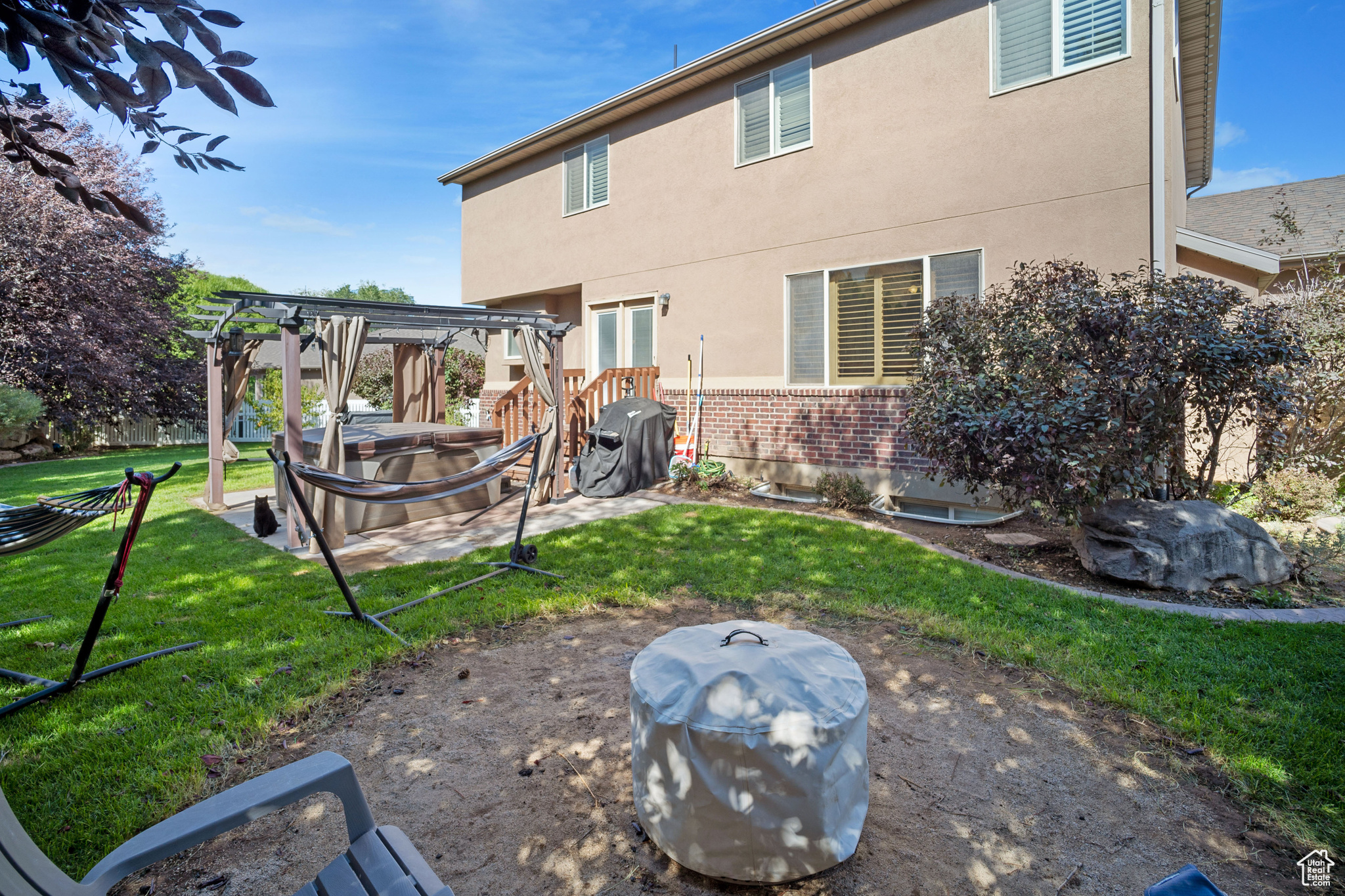 Rear view of house featuring a pergola and a yard