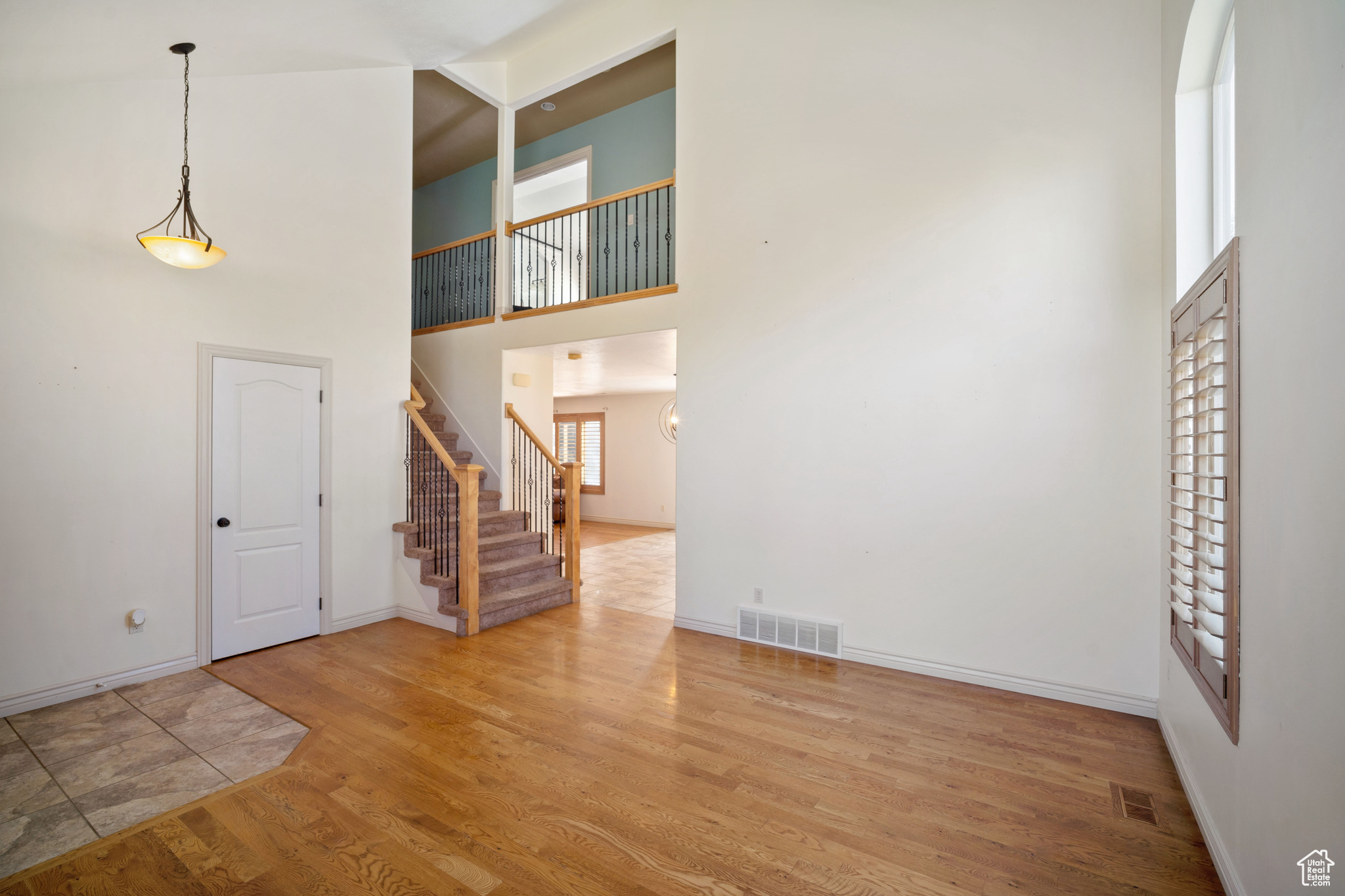 Foyer entrance featuring a towering ceiling and wood-type flooring