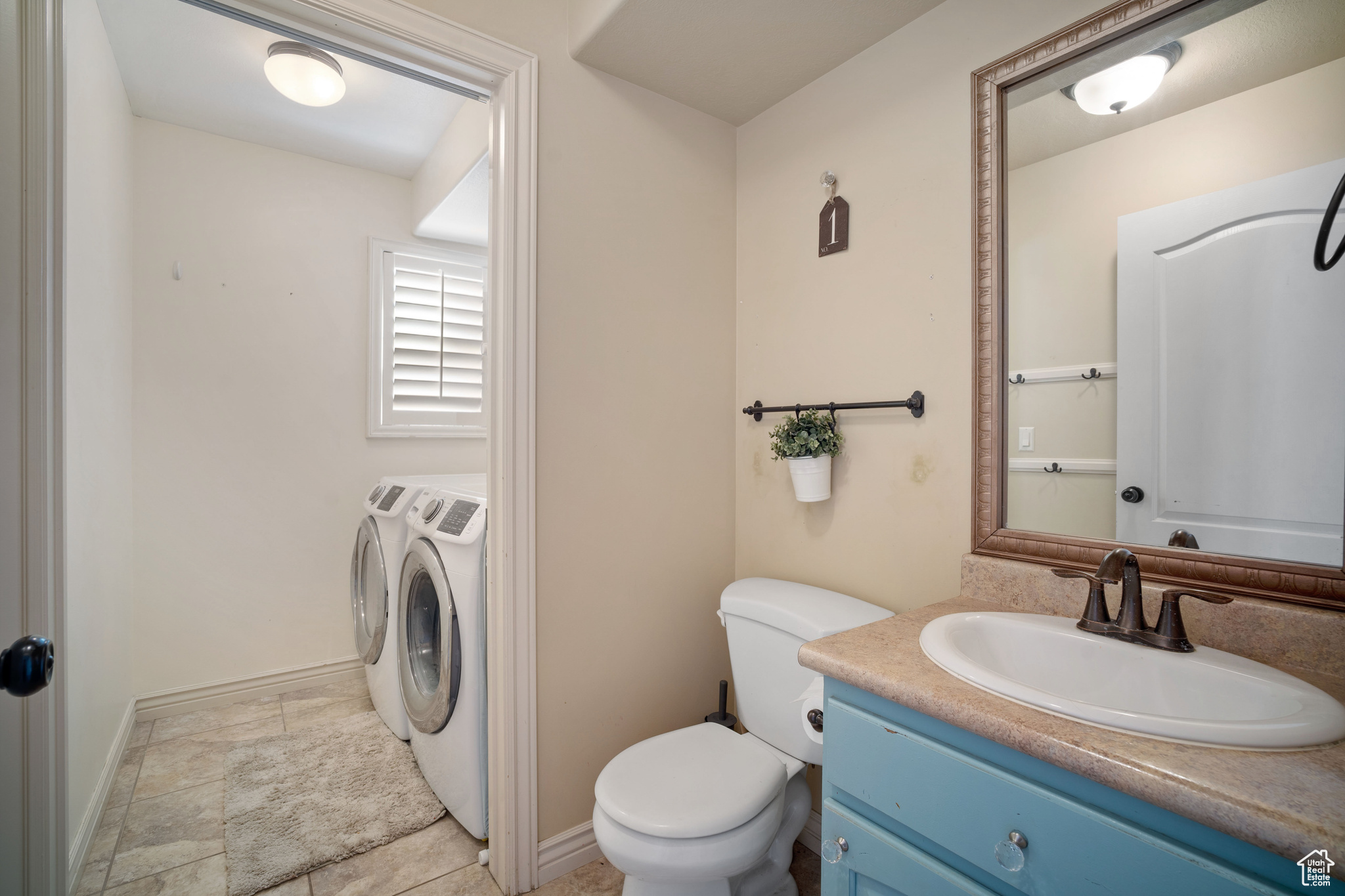 Bathroom featuring vanity, washer and dryer, and toilet