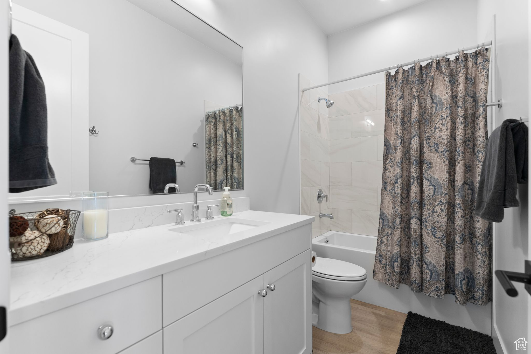 Full bathroom featuring shower / bathtub combination with curtain, vanity, wood-type flooring, and toilet