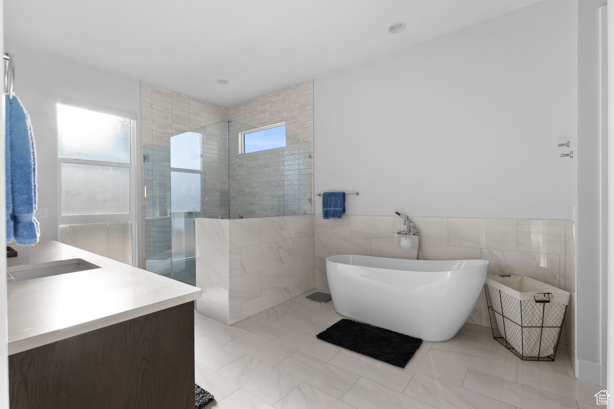 Bathroom with vanity, plus walk in shower, and tile walls