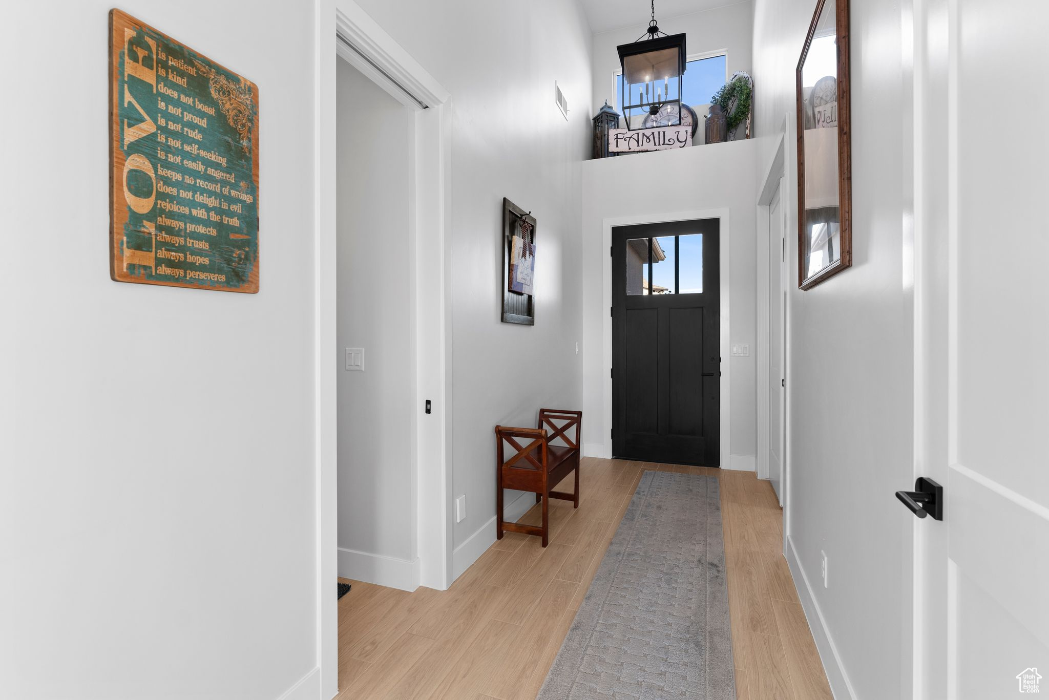 Entrance foyer featuring light wood-type flooring, a high ceiling, and a wealth of natural light.