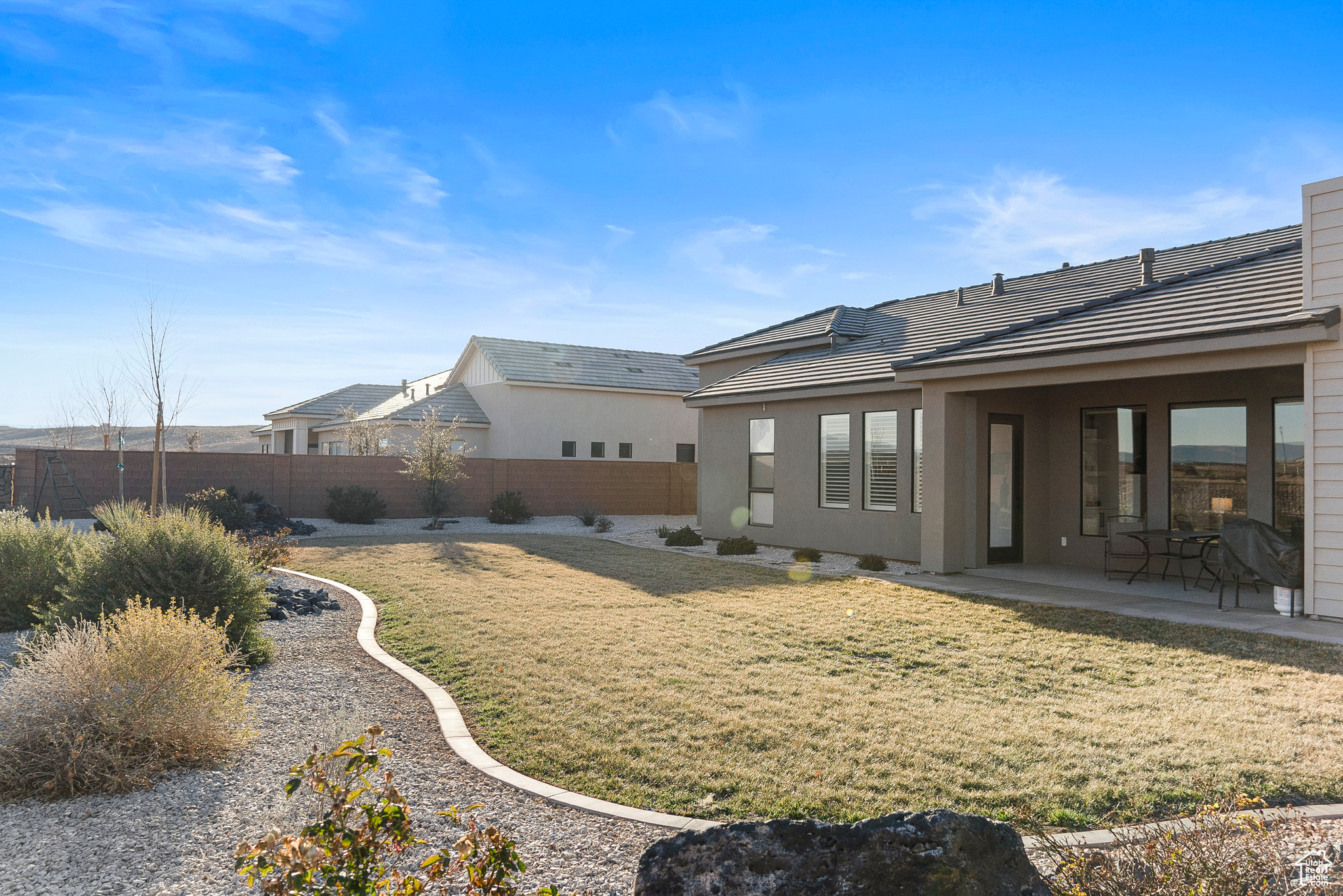 Rear view of house featuring a lawn and a patio