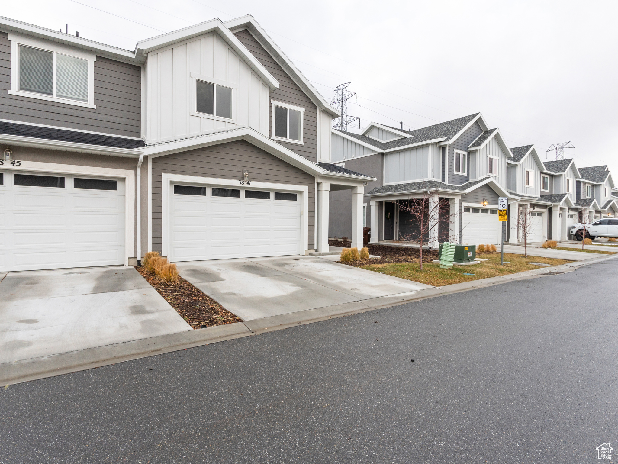 View of front of home featuring central air condition unit and a garage