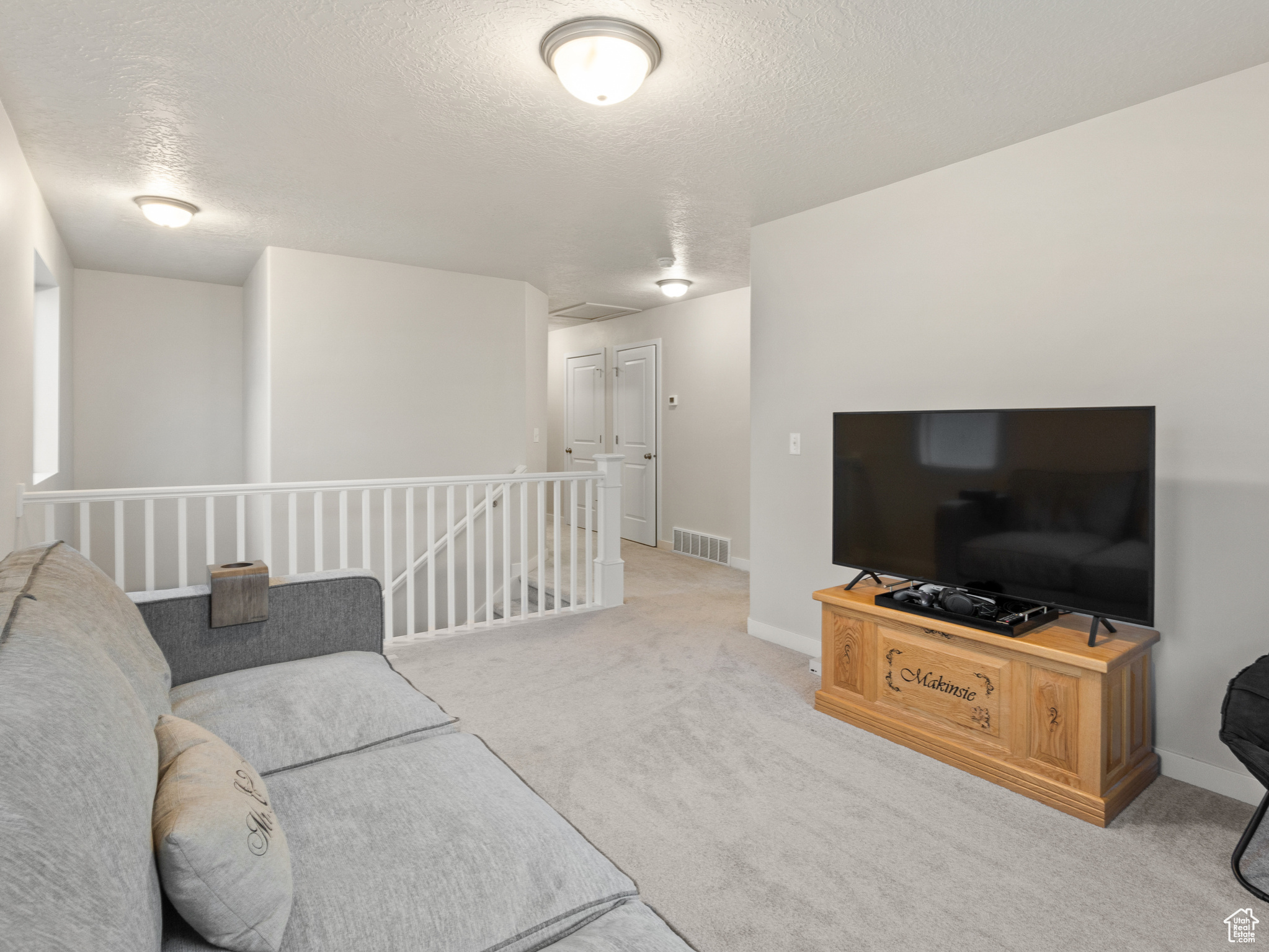 Living room with a textured ceiling and light colored carpet