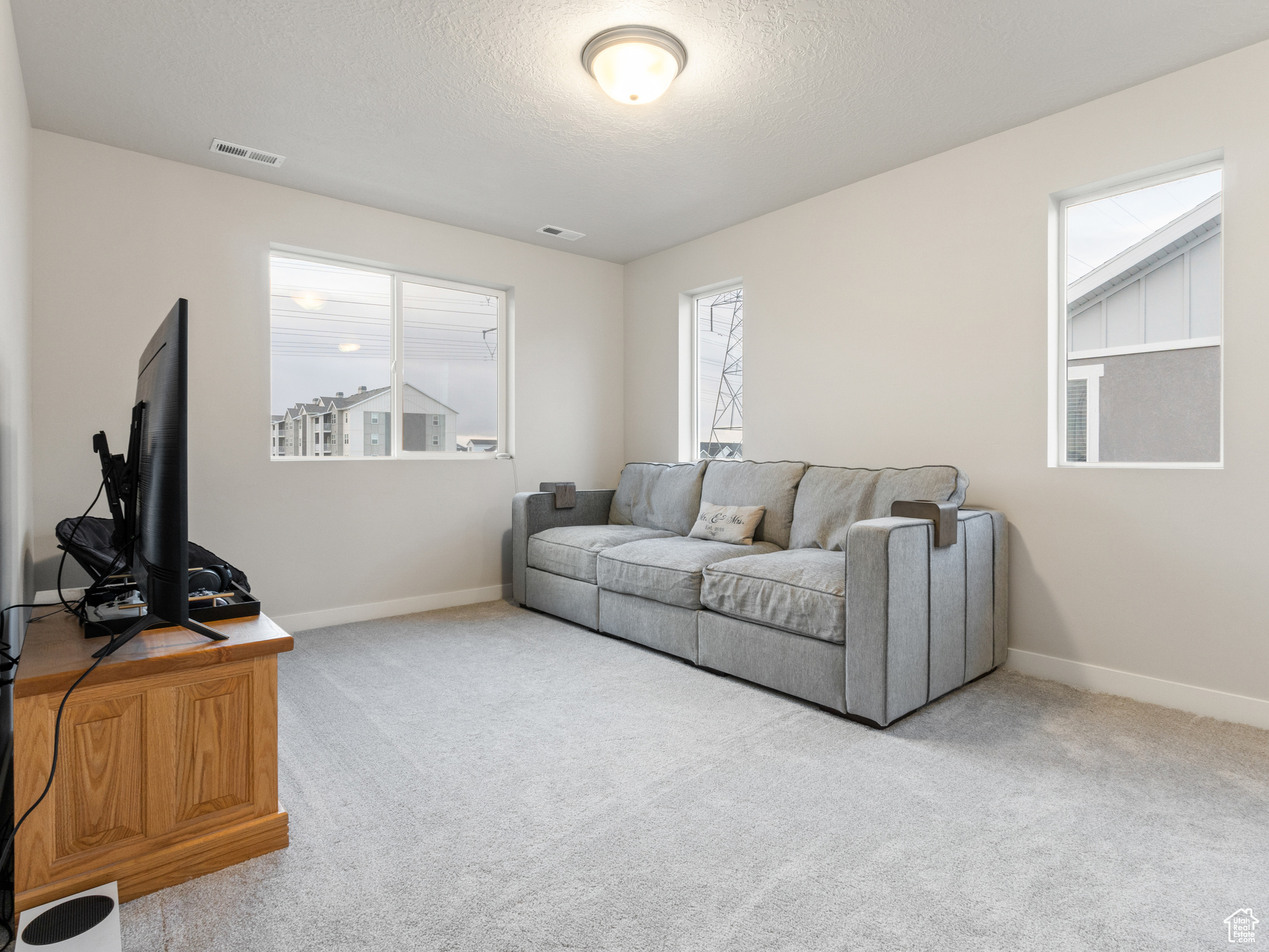 Living room featuring carpet flooring and a textured ceiling