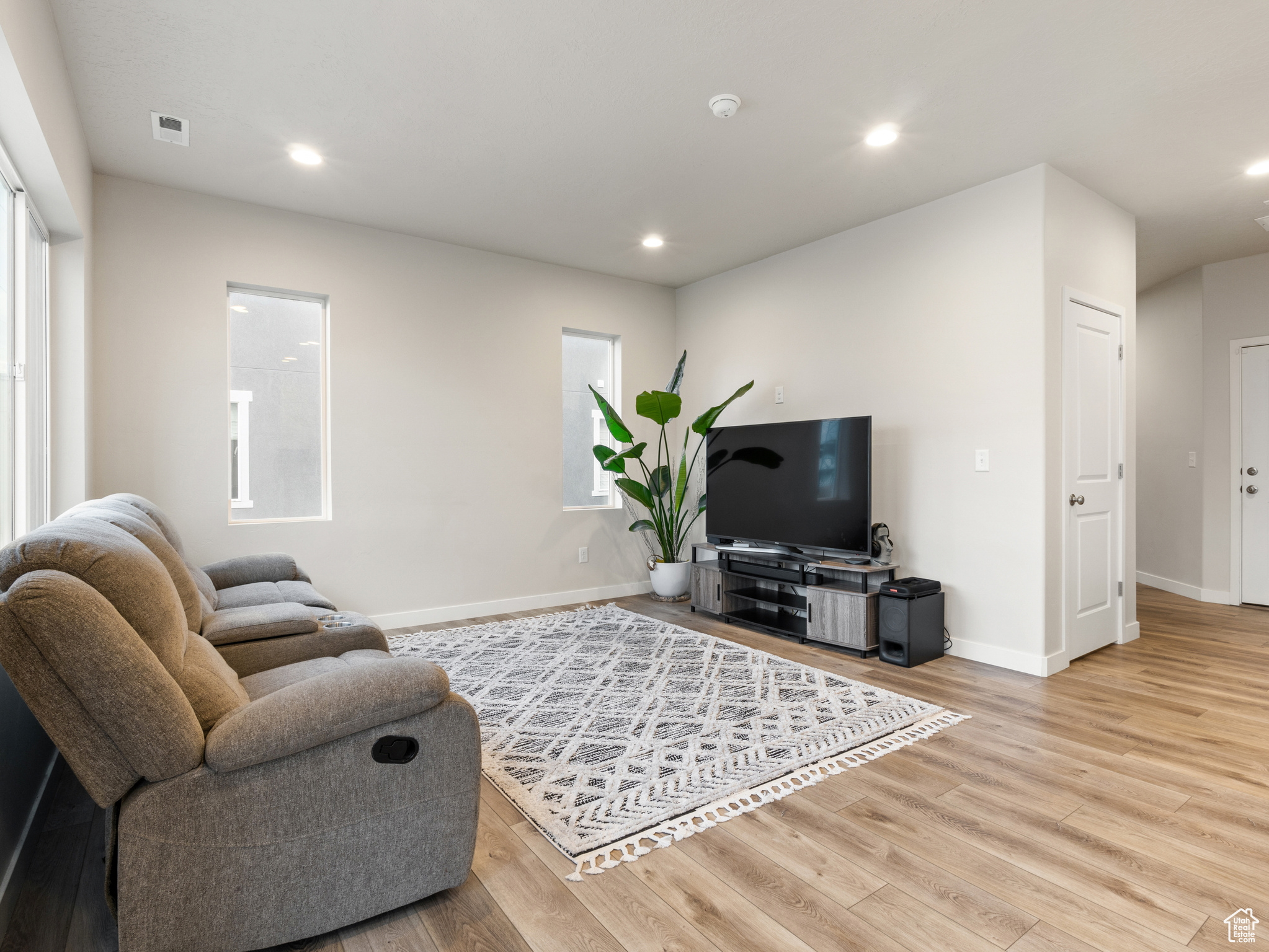 Living room with light hardwood / wood-style flooring and a healthy amount of sunlight