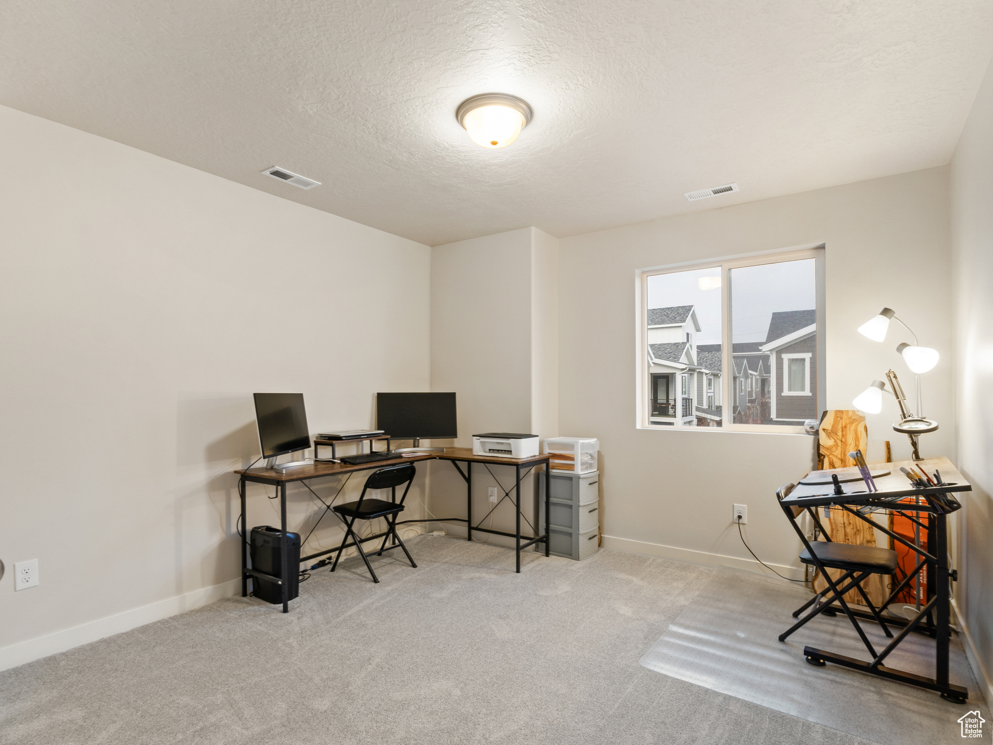 Office featuring a textured ceiling and light carpet