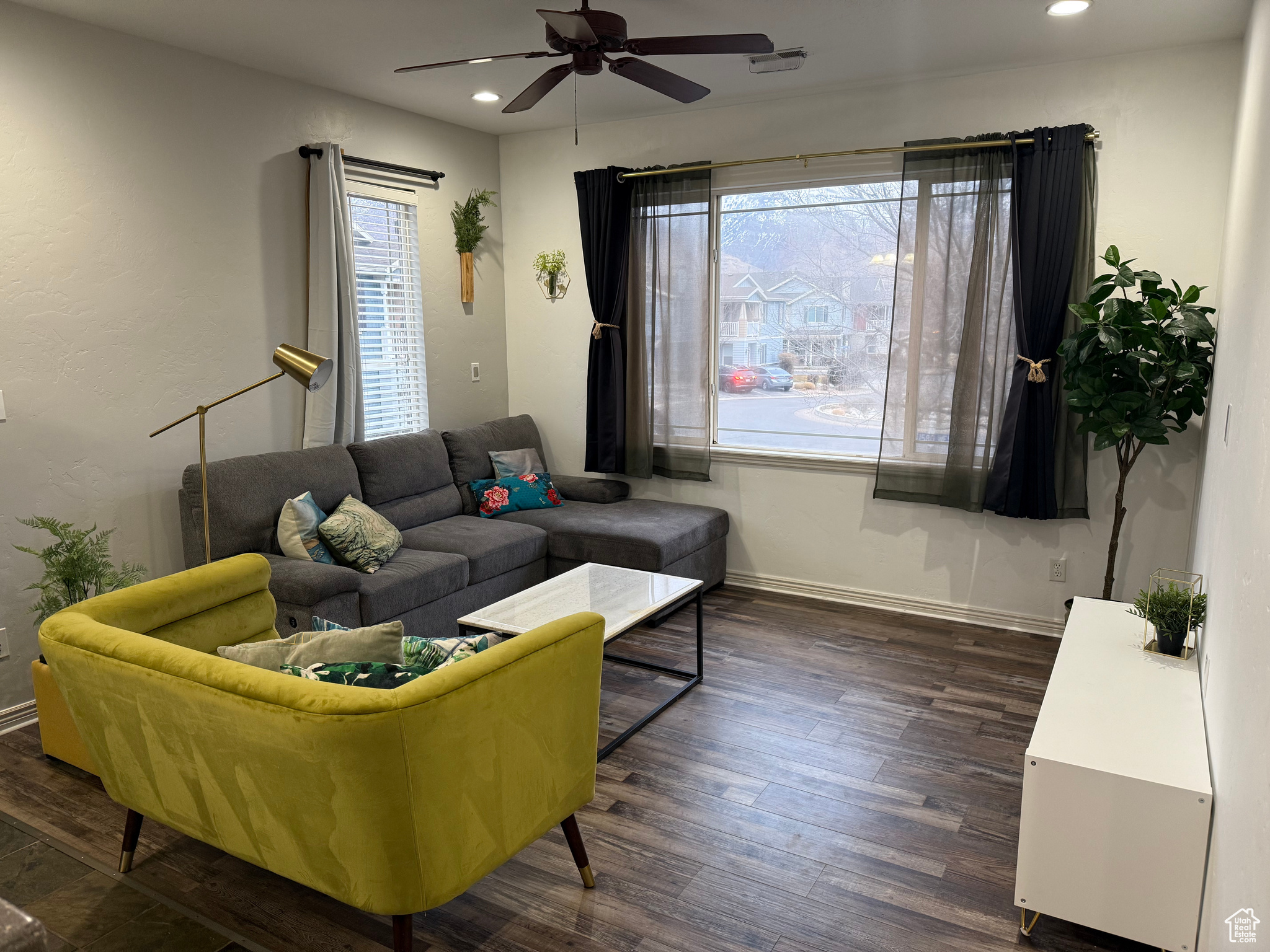 Living room featuring dark hardwood / wood-style flooring, a wealth of natural light, and ceiling fan