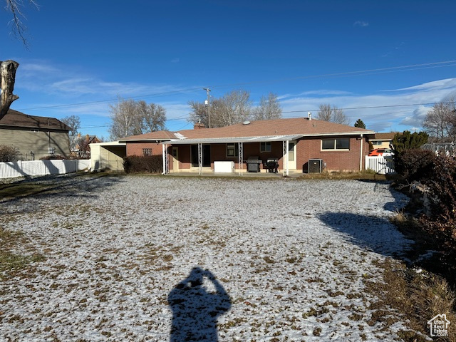 Snow covered property featuring a patio