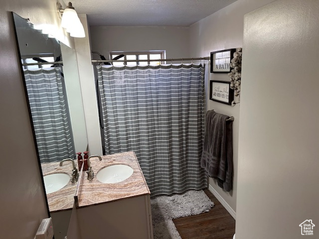 Bathroom with a shower with shower curtain, vanity, and a textured ceiling