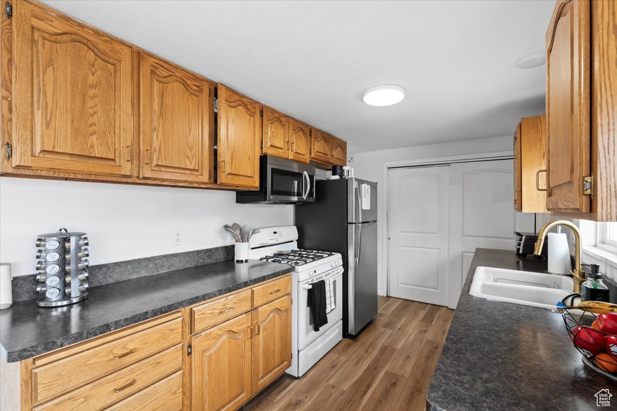 Kitchen with stainless steel appliances, dark wood-type flooring, and sink