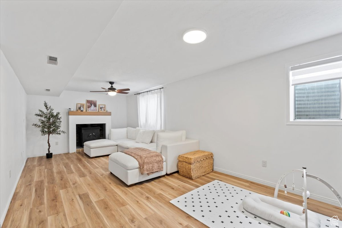 Living room with hardwood / wood-style flooring, ceiling fan, and a wealth of natural light