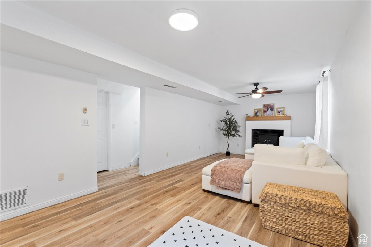 Living room with ceiling fan and hardwood / wood-style flooring