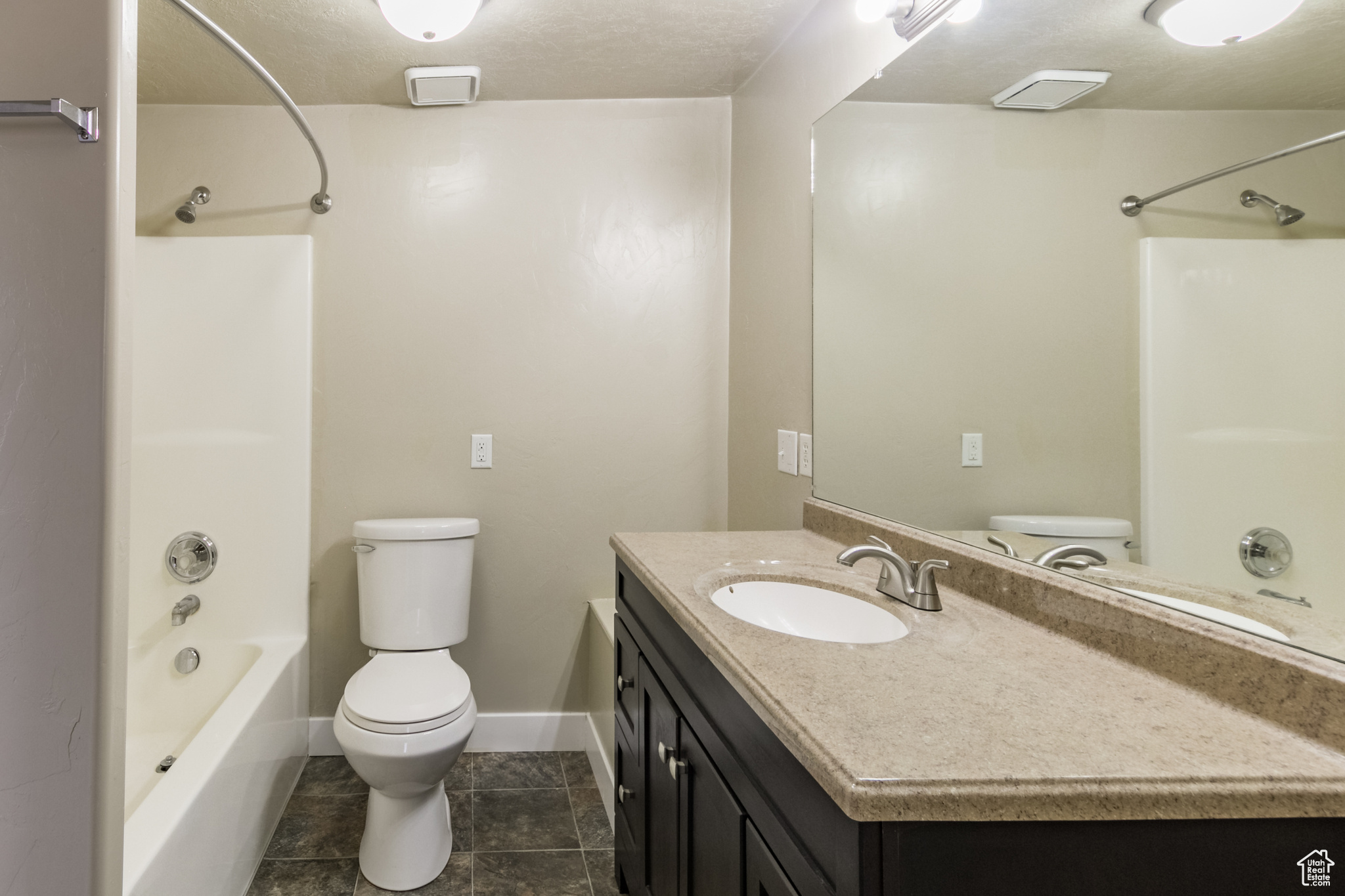 Full bathroom featuring tile patterned floors, vanity, toilet, and shower / washtub combination