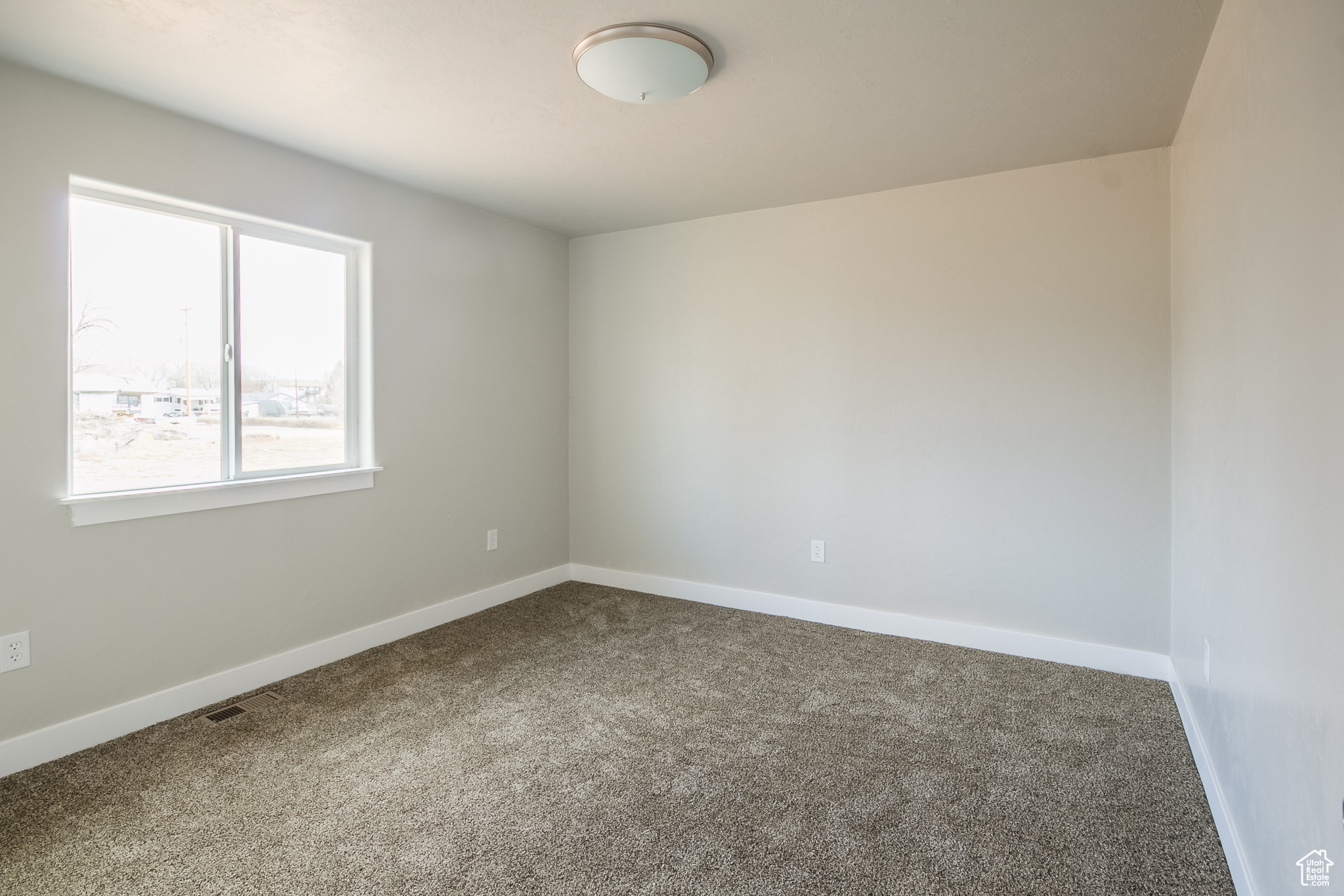 Spare room with plenty of natural light and carpet