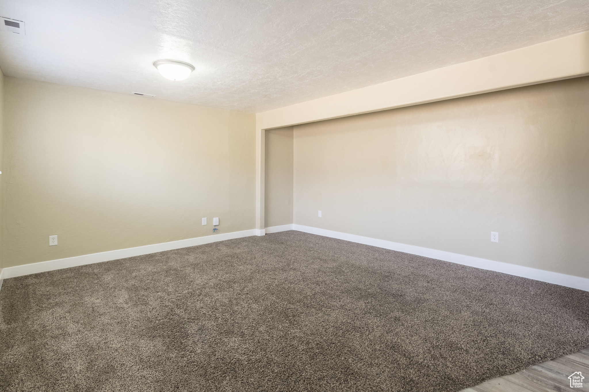 Unfurnished room featuring a textured ceiling