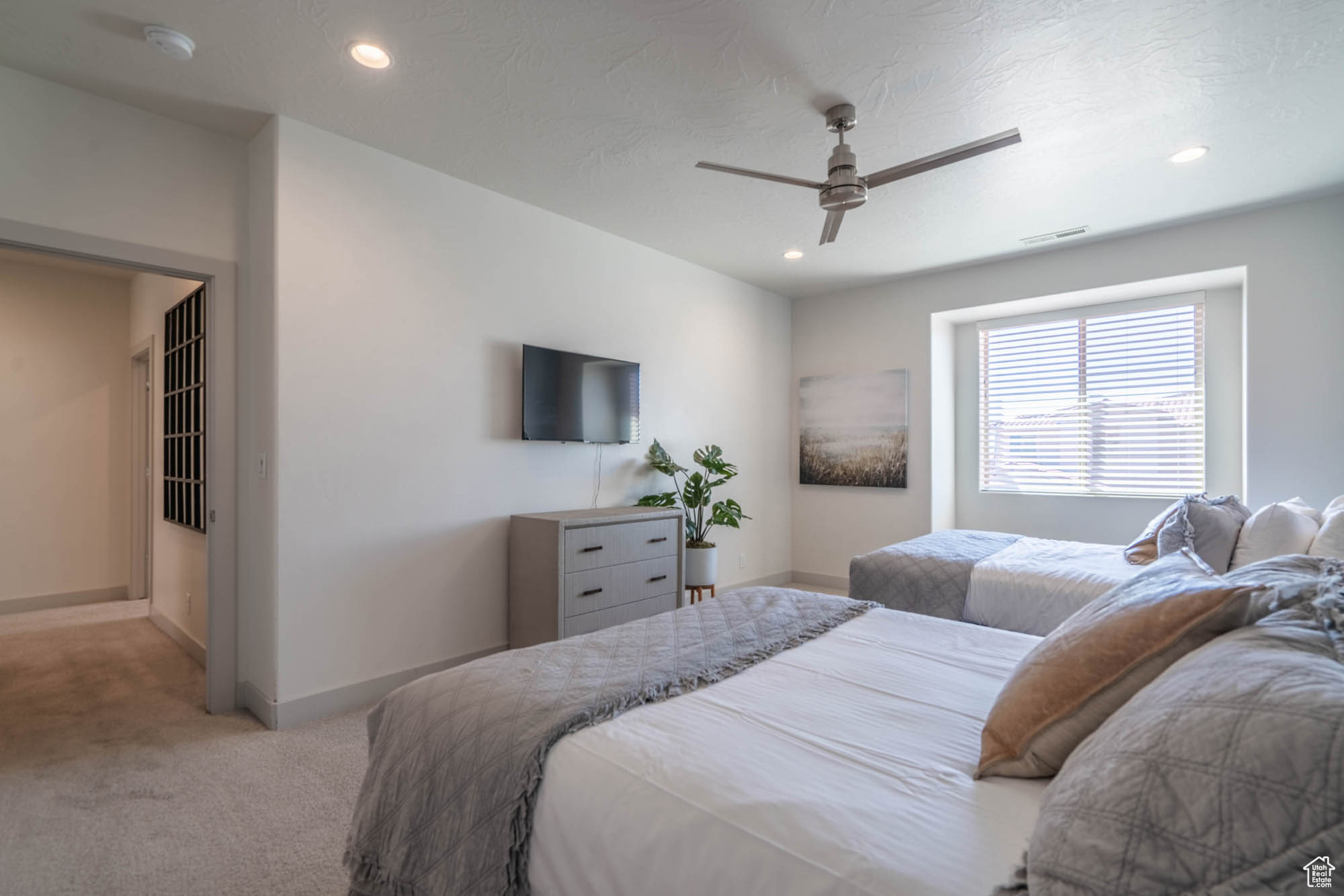 Carpeted bedroom featuring ceiling fan