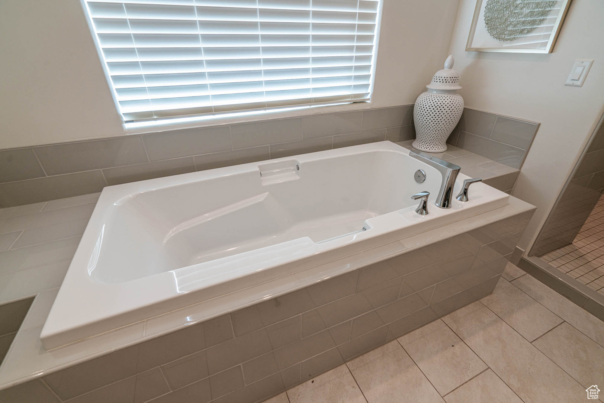 Bathroom featuring tile patterned floors and tiled tub