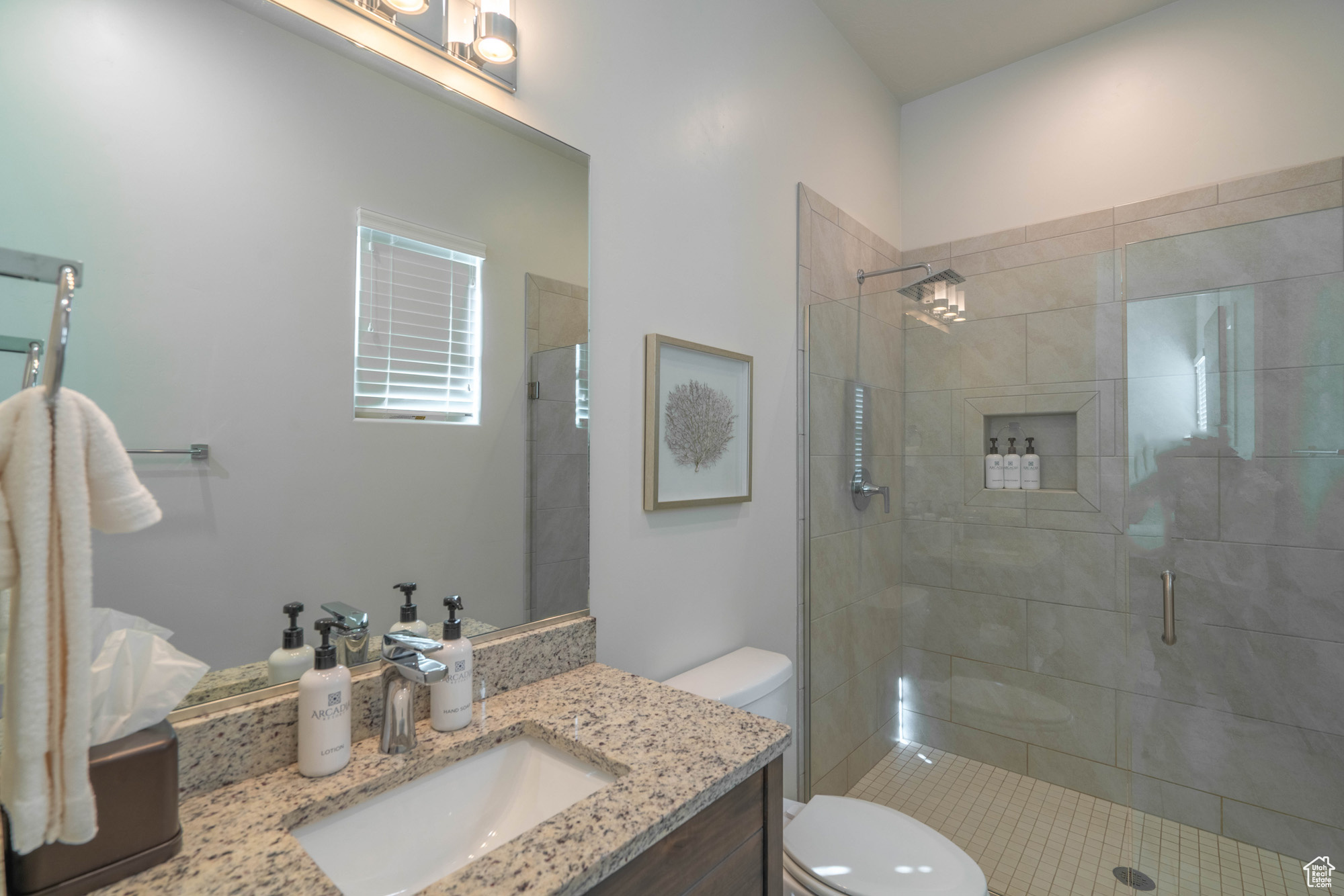 Bathroom featuring vanity, toilet, and a shower with shower door