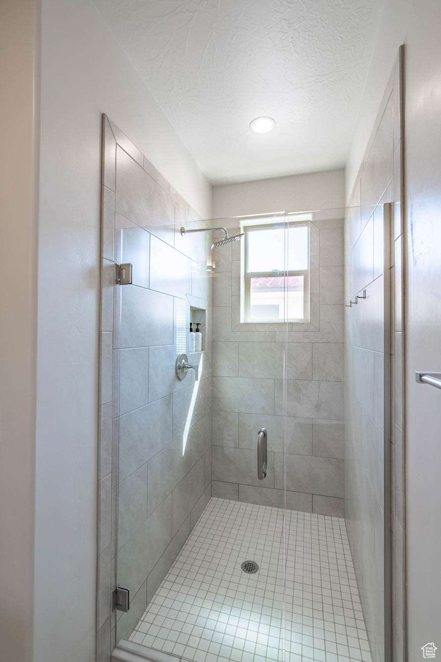 Bathroom with a textured ceiling and an enclosed shower