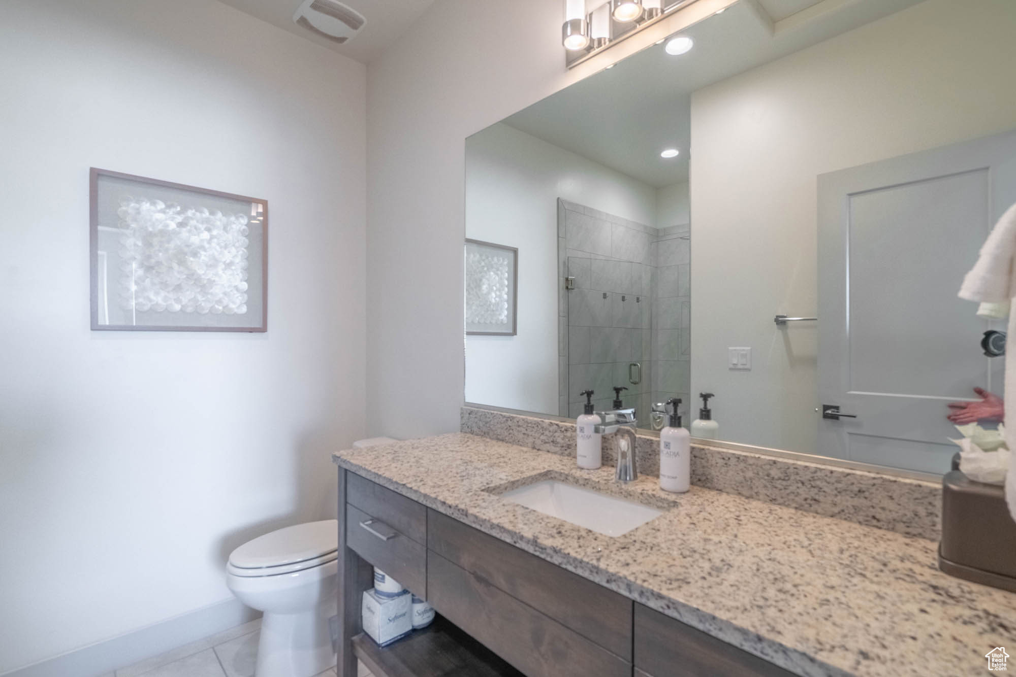 Bathroom with tile patterned floors, vanity, toilet, and walk in shower