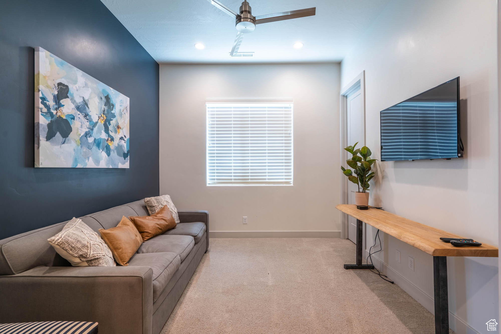 Carpeted living room with ceiling fan