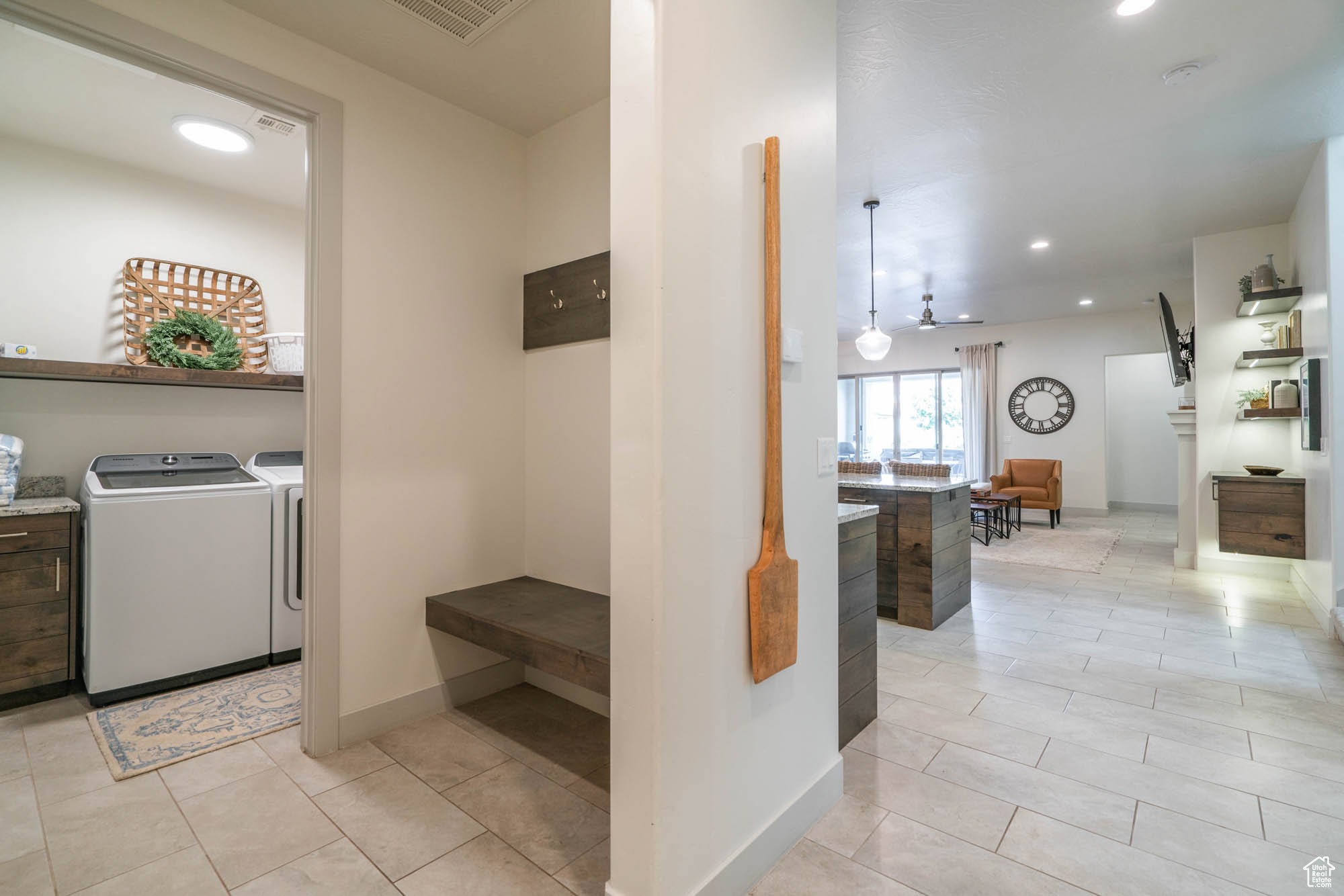 Washroom featuring washing machine and dryer, ceiling fan, and light tile patterned floors