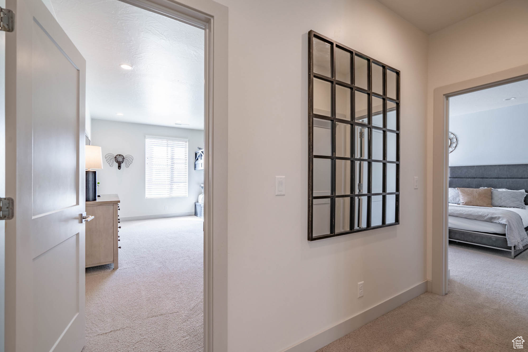 Corridor featuring light colored carpet