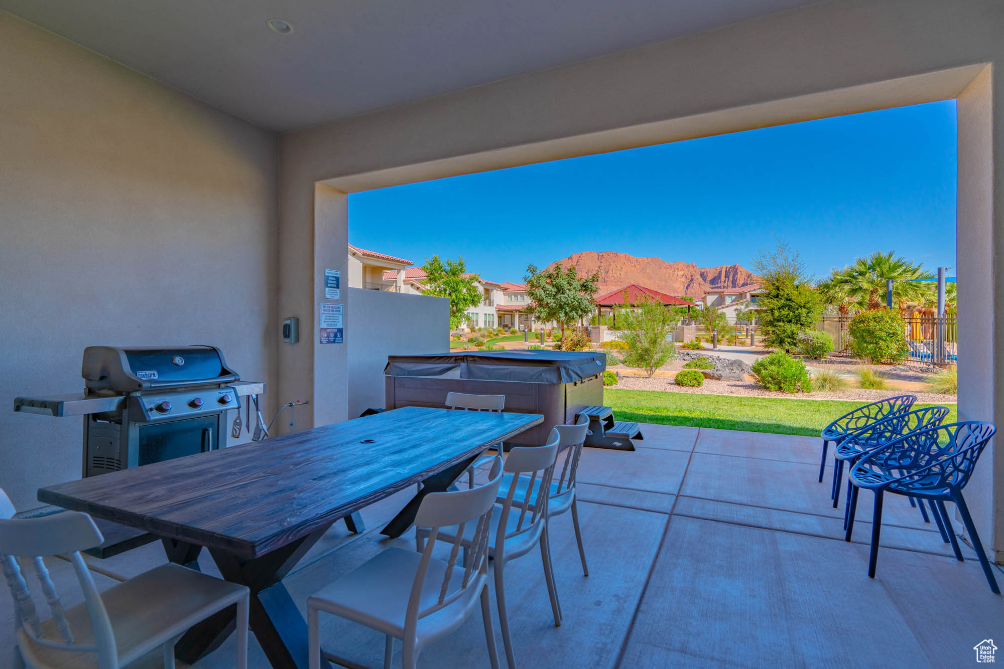 View of patio with a mountain view, area for grilling, and a hot tub