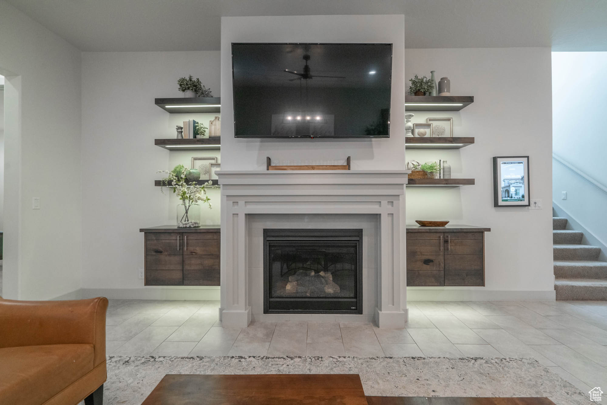 Tiled living room featuring ceiling fan and a fireplace