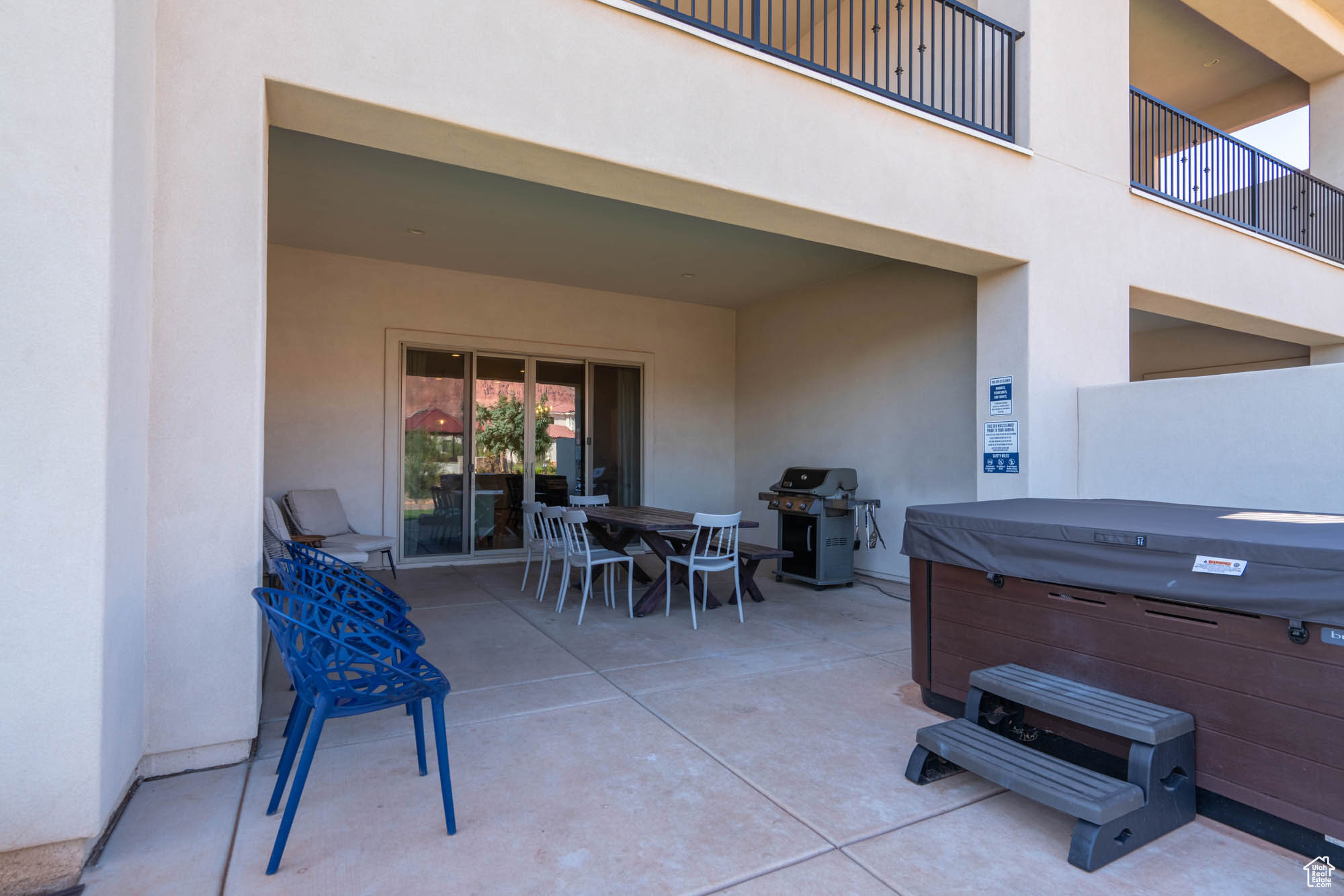 View of patio with area for grilling and a hot tub