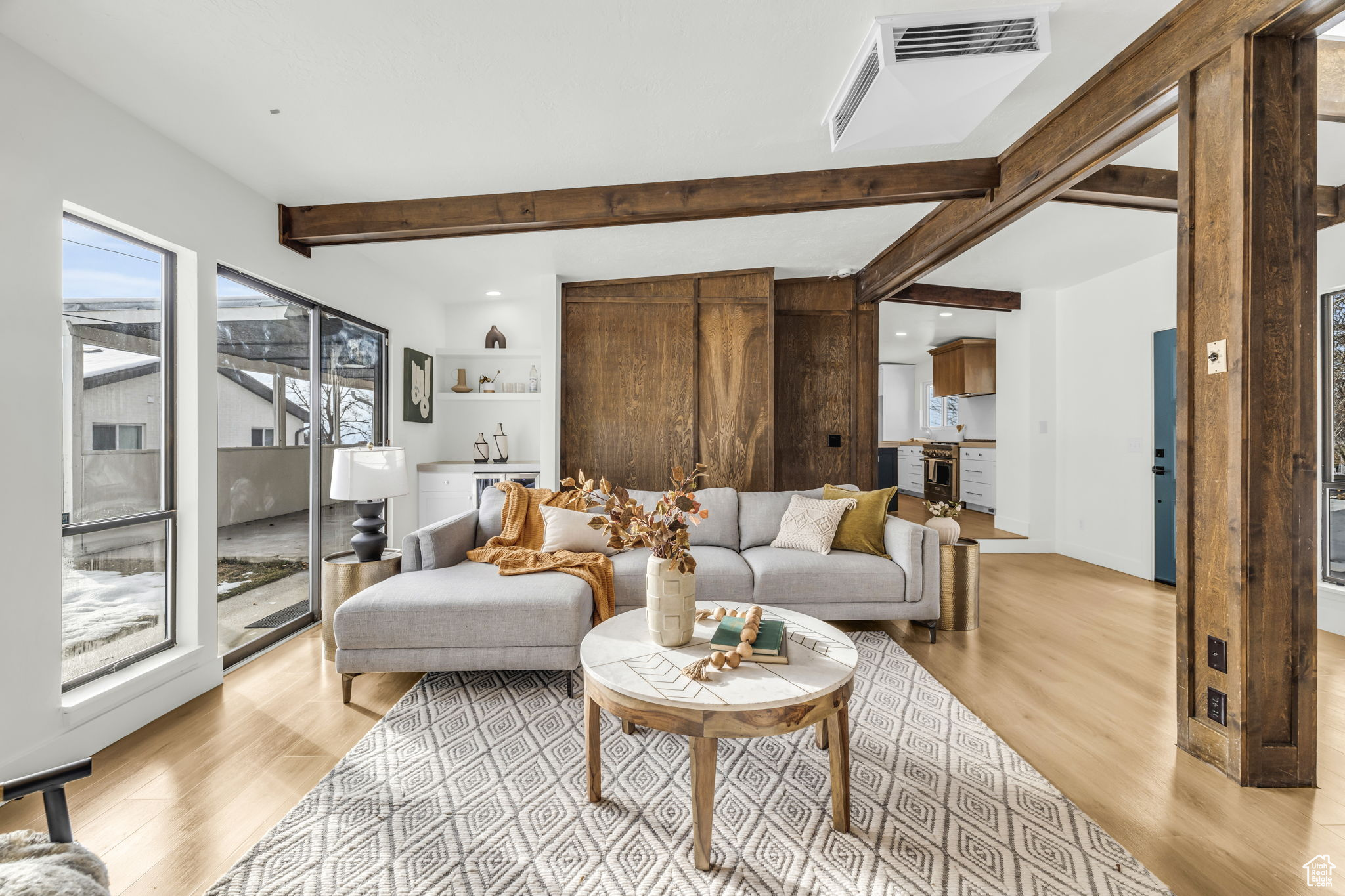 Living room with beam ceiling and light wood-type flooring